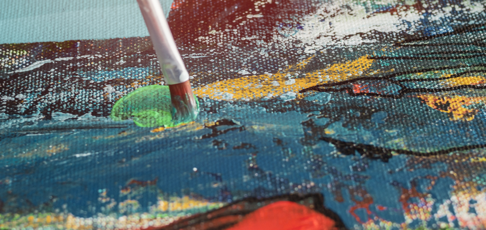 Zdjęcie przedstawia powstawanie obrazu. Na ujęciu z bliska pędzel dotyka powierzchni płótna pozostawiając nieregularne plamy barwne. Jedne z nich są ciepłe, inne zimne. Na plamy wchodzą z boku zygzakowate linie rysowane cienkim konturem. 