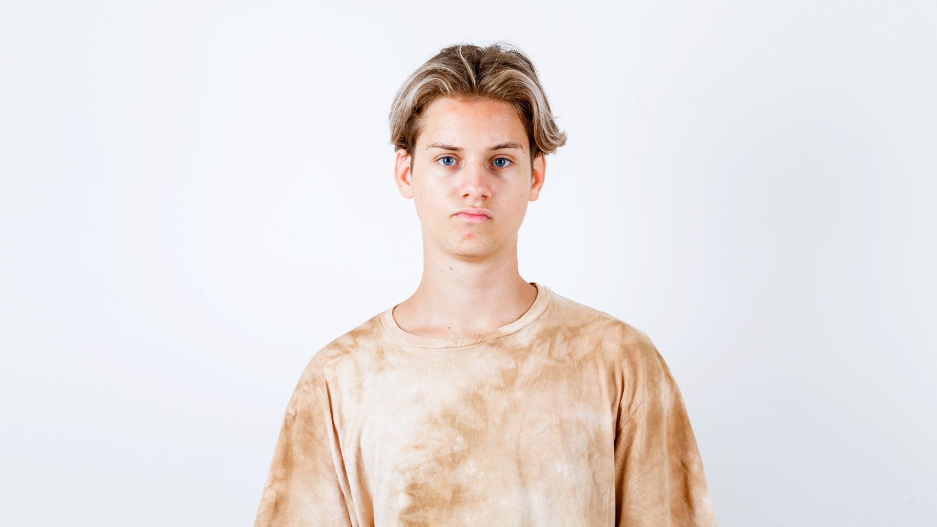 Zdjęcie przedstawia nastoletniego, niezadowolonego chłopaka. 