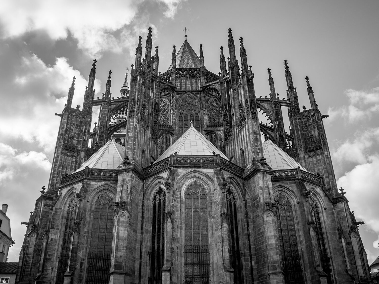 Czarno białe zdjęcie przedstawia budowle. Widoczny jest front budynku, który zdobią okna oraz strzeliste wieże. Nad wejściem widoczna płaskorzeźba przedstawiająca postacie. 