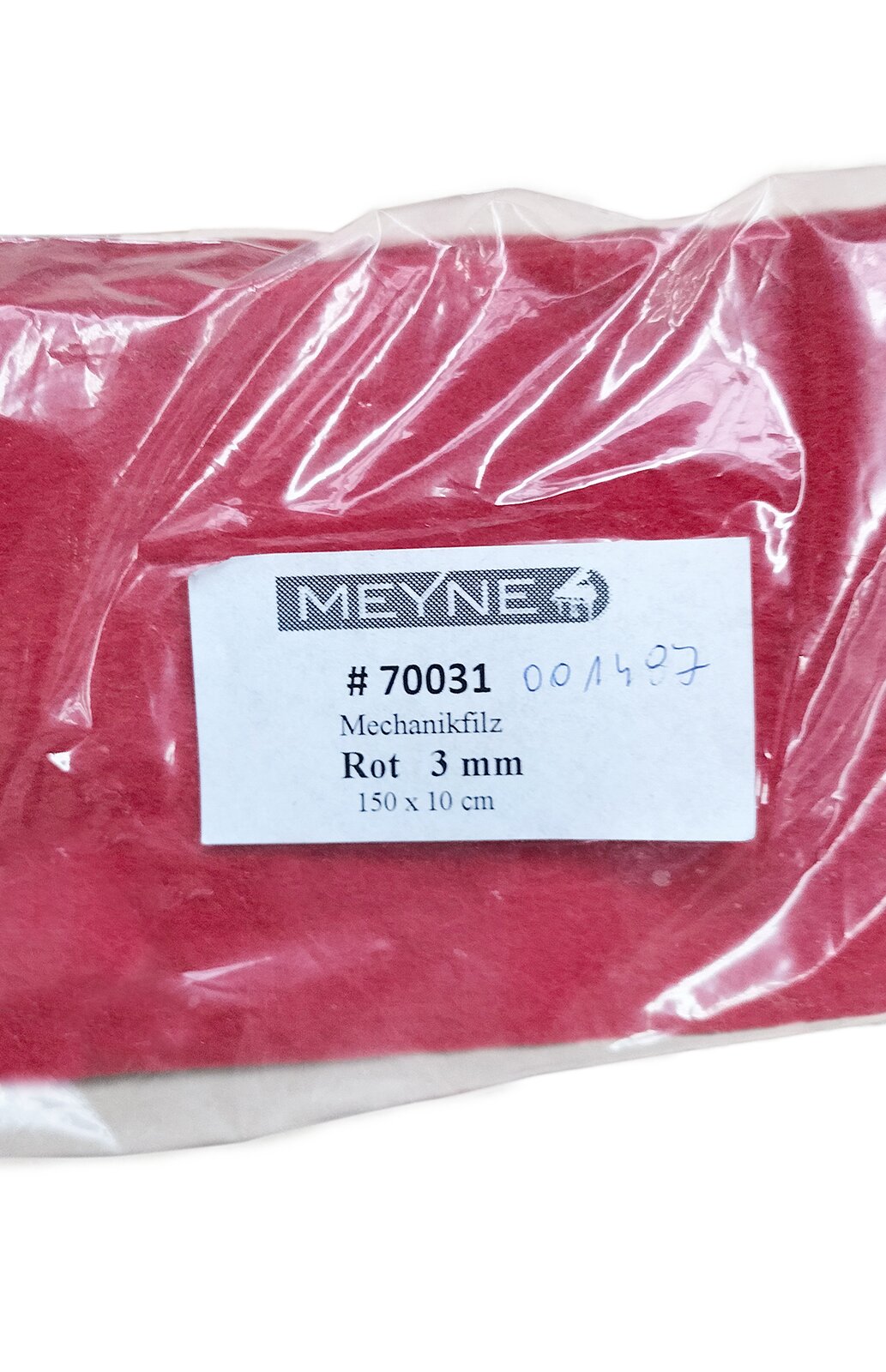 Zdjęcie przedstawia filc bity. Widoczny jest płat czerwonego filcu w ujęciu z góry, w przeźroczystym foliowym opakowaniu z białą etykietą pośrodku, z czarnymi napisami.