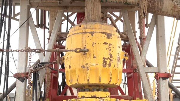 Na zdjęciu widoczna jest głowica przeciwerupcyjna uniwersalna. Urządzenie jest przeznaczone do zamknięcia wylotu otworu wiertniczego przy wierceniach obrotowych w celu przeciwdziałania erupcji płynu złożowego. Urządzenie kształtem przypomina sporej wielkości walec, lekko zaokrąglony u góry i dołu.. Pod walcem znajduje się platforma z informacją o nośności sześćdziesięciu ton. Do głowicy przymocowane są łańcuchy. Nad głowicą widoczny jest wychodzący z niej przewód wiertniczy.