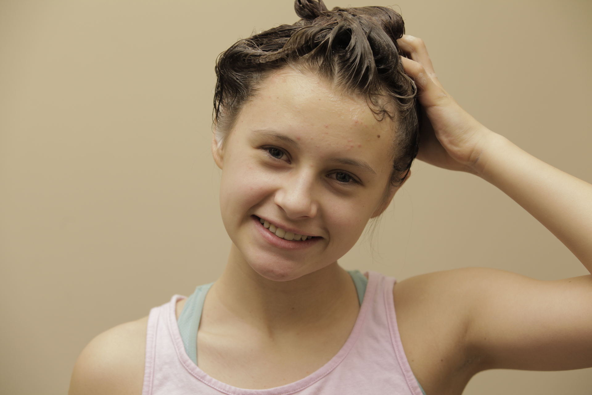 Fotografia przedstawiająca młodą dziewczynę myjącą włosy