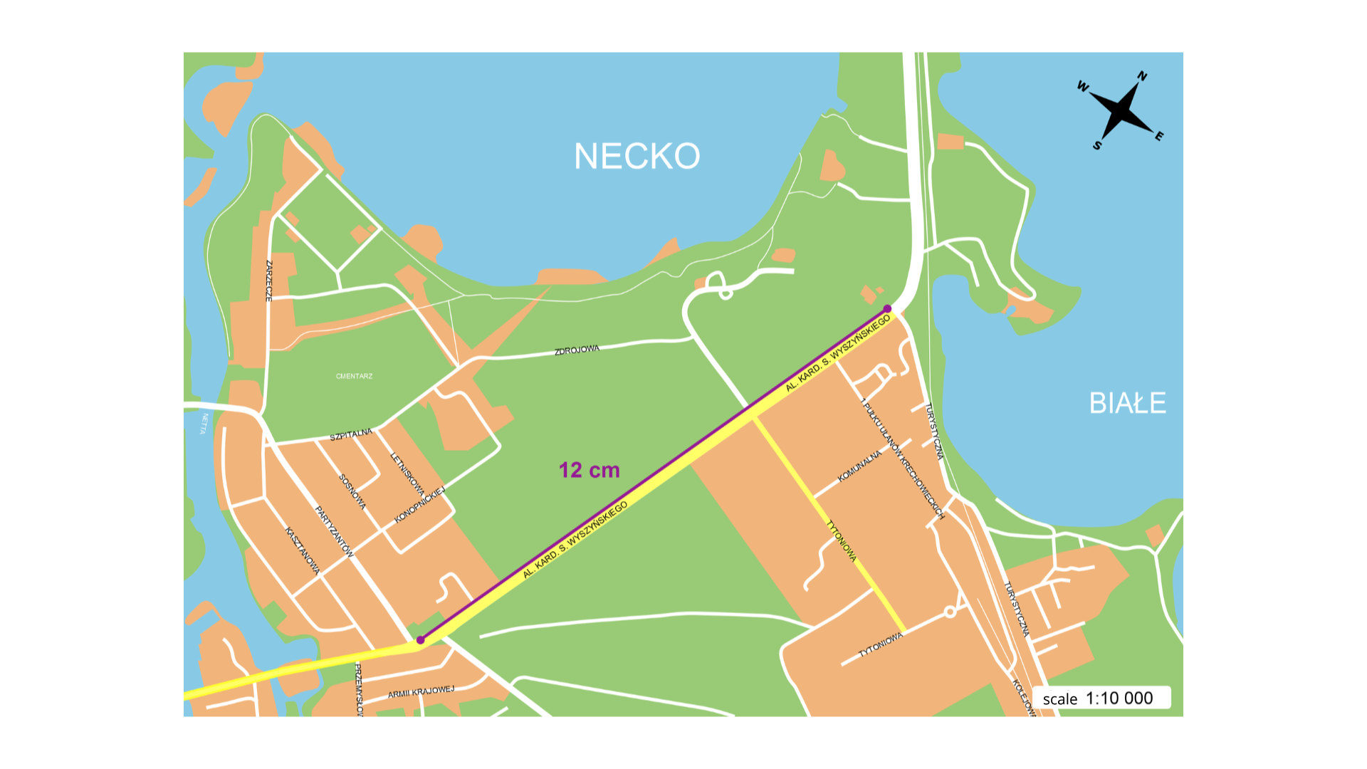 Rysunek przedstawia fragment planu Augustowa. Skala mapy wynosi jeden do dziesięciu tysięcy. Na planie narysowano odcinek o długości 12 cm wskazujący odległość od skrzyżowania alei Kardynała Stefana Wyszyńskiego z ulicą Partyzantów do skrzyżowania ulicy Turystycznej. 