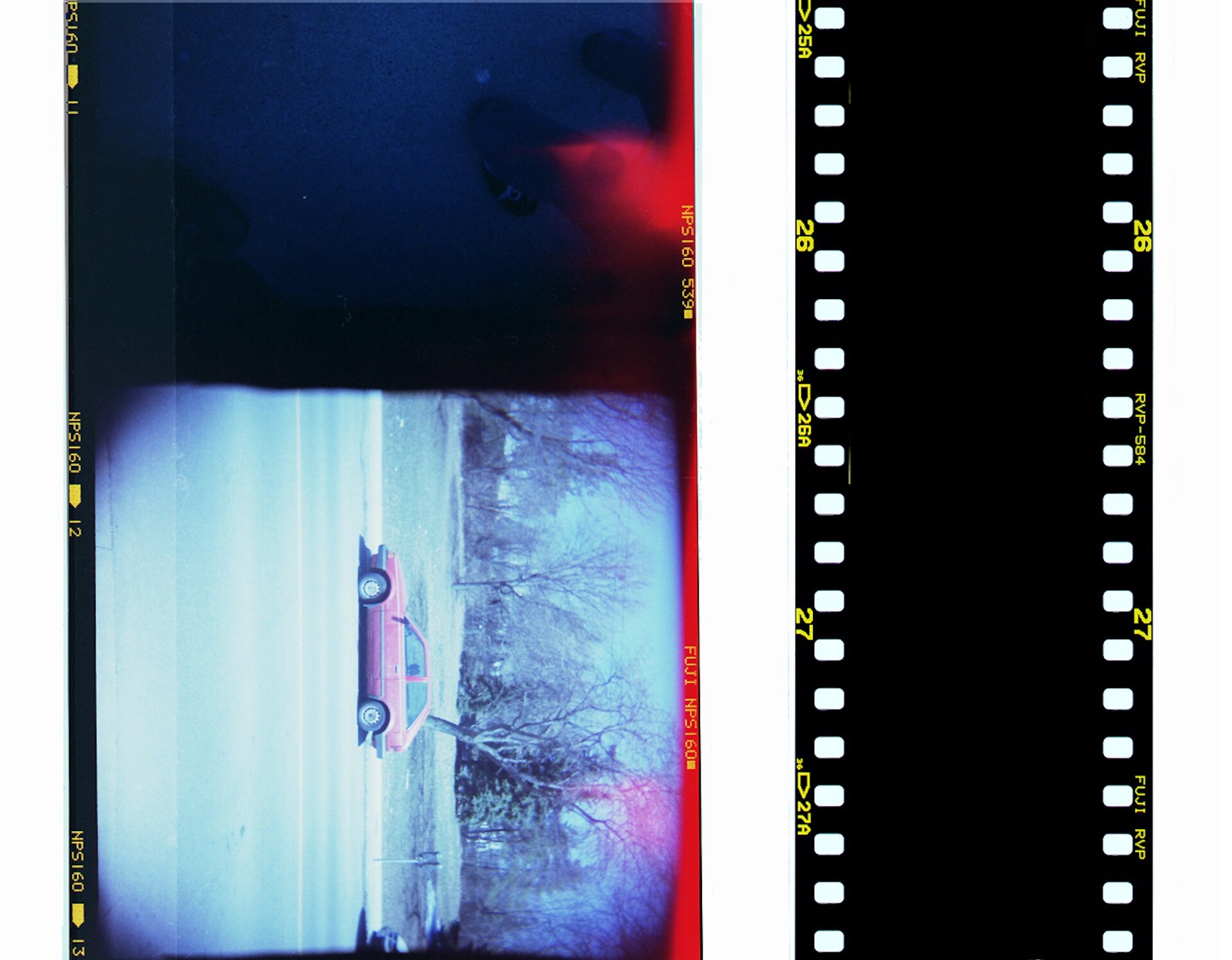 Ilustracja przedstawia kliszę fotograficzną. Obraz znajduje się na podłużnym cienkim pasku. Po bokach znajdują się prostokątne otwory.