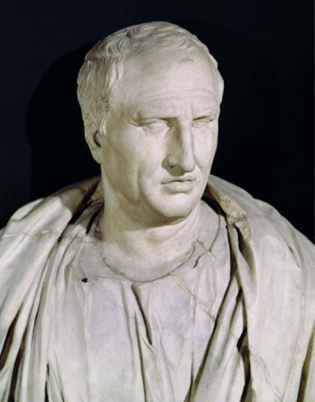 Fotografia przedstawiająca popiersie Marka Tuliiusza Cycerona. Mężczyzna ma krótkie, kręcone włosy, długi nos i wąskie usta. Na ramionach ma zarzuconą szatę, która prawdopodobnie jest togą.
