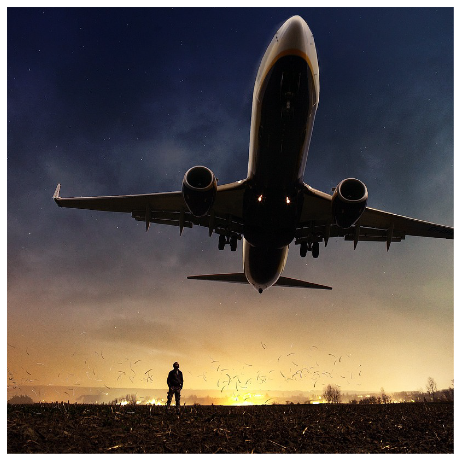 Na zdjęciu widoczny jest startujący samolot. Start obserwuje jedna osoba stojąca na płycie. 