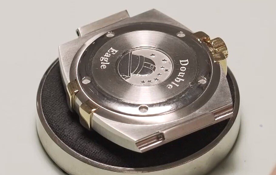 Grafika przedstawia spodnią część zegarka, na której umieszczone są opisy producenta (np. nr. referencyjny, seryjny, informacje o wodoszczelności itp.) Dekiel zamyka kopertę i zabezpiecza jego mechanizm przed uszkodzeniami.