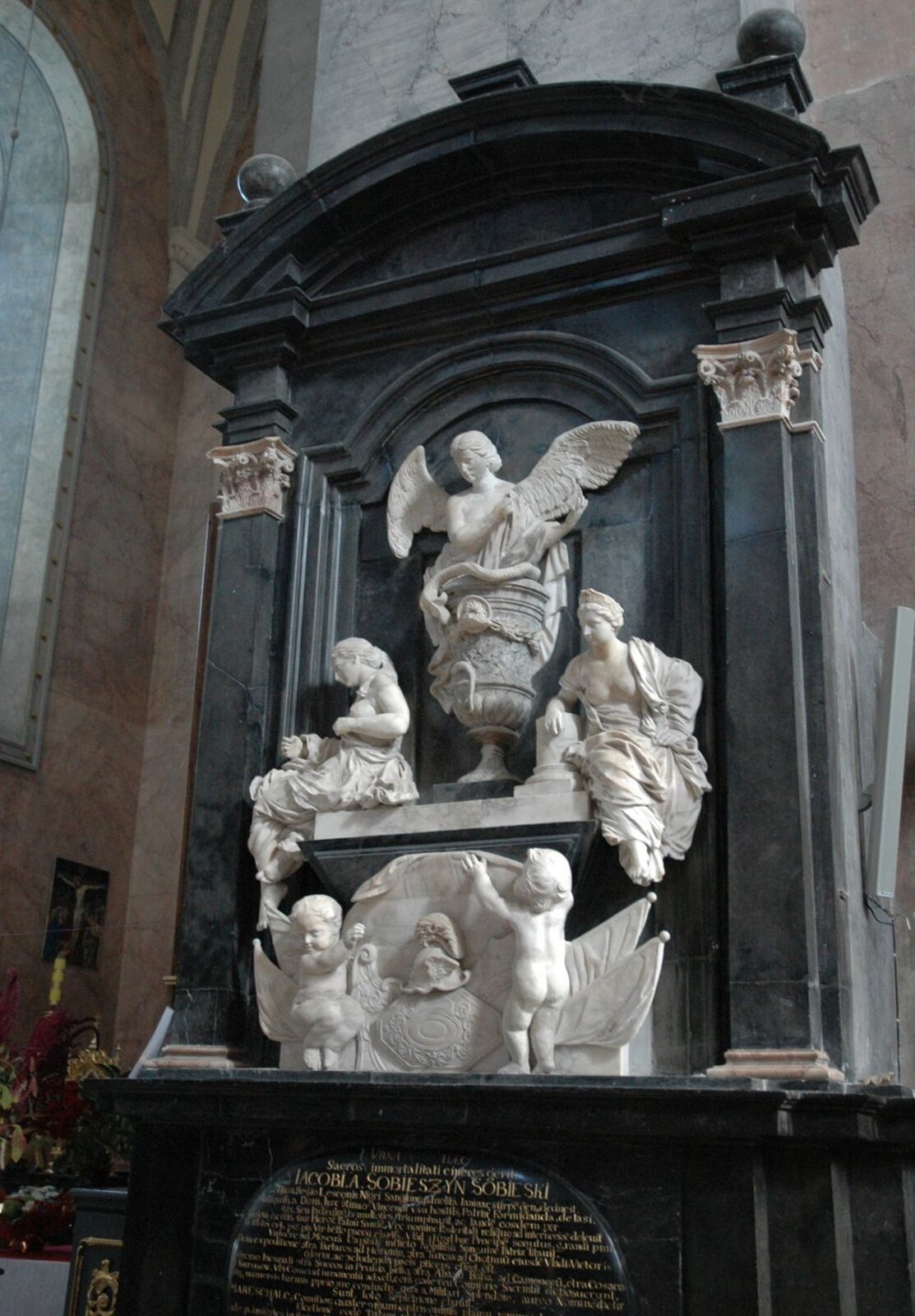 Ilustracja o kształcie pionowego prostokąta przedstawia nagrobek Jakuba Sobieskiego. Tło architektoniczne stanowi jednokondygnacyjne założenie z półokrągłym tympanonem u góry i pilastrami po bokach, dekorowanymi głowicami w stylu korynckim. Główną, środkową część zdobią rzeźby. W centralnym punkcie jest anioł ze skrzydłami umieszczony w kielichu. Po jego bokach rzeźby siedzących, dwóch półnagich kobiet. Jeszcze niżej umieszczono dwoje małych nagich dzieci. W dolnej części zamontowana jest tablica ze złoconym tekstem.