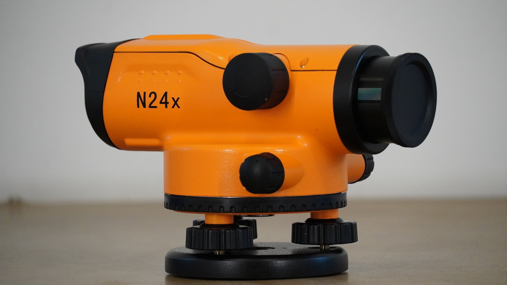 Na zdjęciu przedstawiono zbliżenie niwelatora. Po prawej stronie widoczny jest obiektyw. Na samym dole znajduje się okrągły czarny element, to spodarka. Na niej mieszczą się trzy śruby, na nich zaś koło poziome z podziałką stanowiące dolną część okrągłego korpusu. Z boku korpusu znajduje się czarne pokrętło leniwki, a na korpusie podłużna luneta, która z jednej strony posiada węższy okular, a z drugiej – obiektyw.