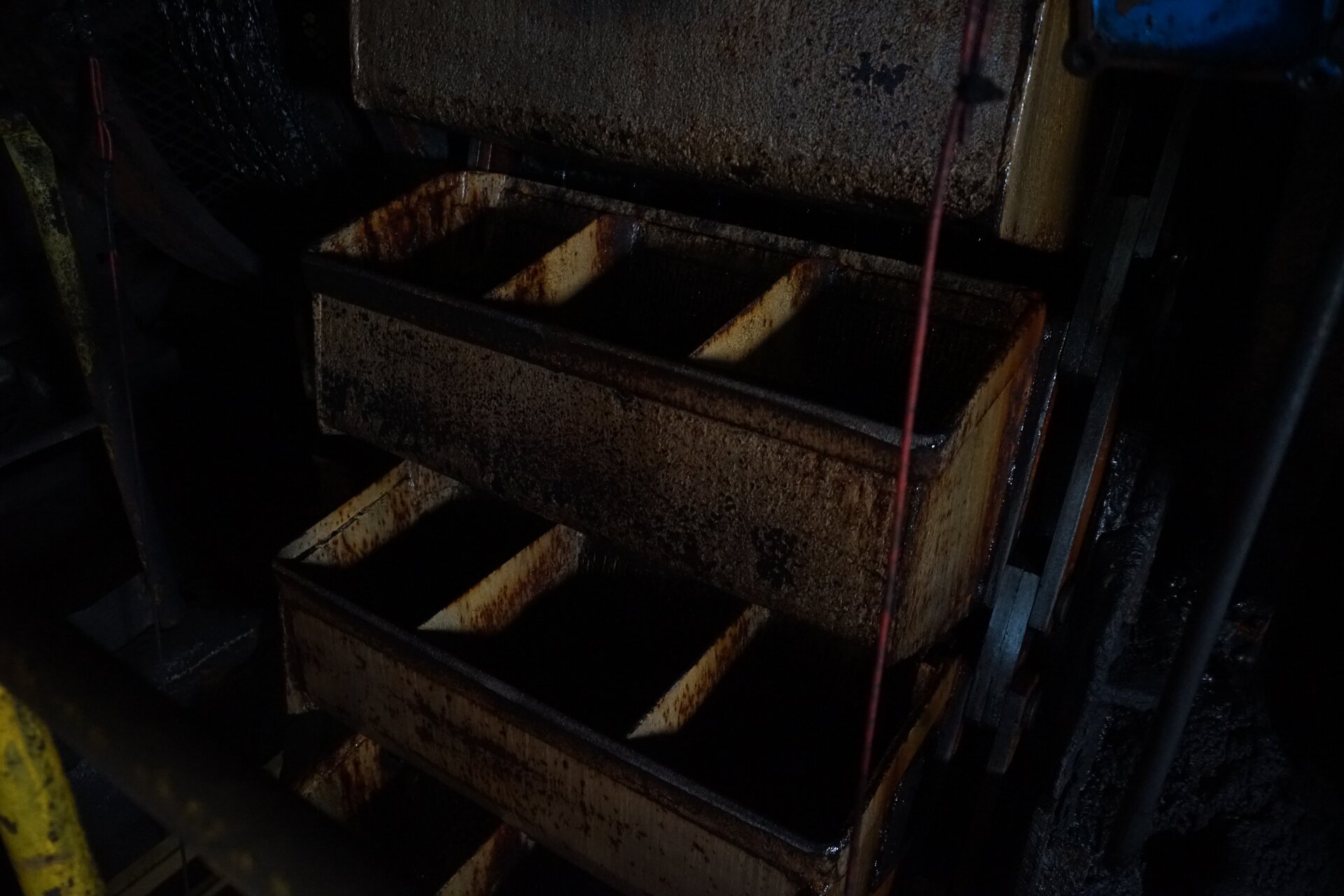 Zdjęcie przedstawia przenośnik kubełkowy. Składa się on ze zbiorników z wydzielonymi trzema komorami. Przekrój zbiorników w górnej części stanowi prostokąt. Natomiast u dołu ich ścianki są zaokrąglone. Są one rozmieszczone od dołu do góry i tak też są kierowane. Poniżej zdjęcia znajduje się przycisk multimedialny z nagraniem audio. Treść nagrania jest zgodna z tytułem zdjęcia.