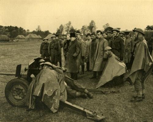 Zdjęcie przedstawia grupę mężczyzn, która zgromadzona jest wokół działa armatniego.