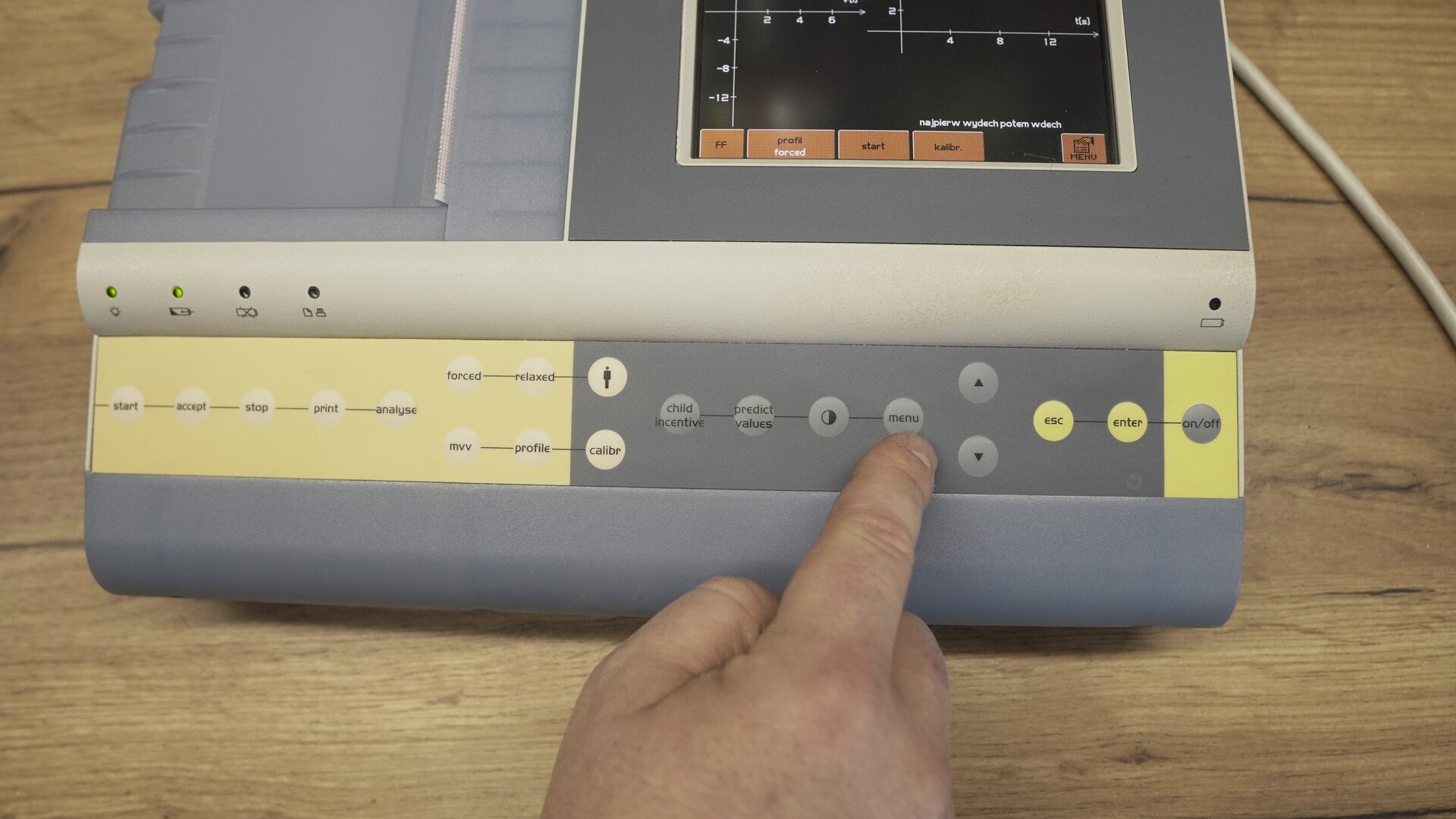 Na zdjęciu przedstawiono test klawiatury spirometru - technik wciska przyciski Menu na obudowie.