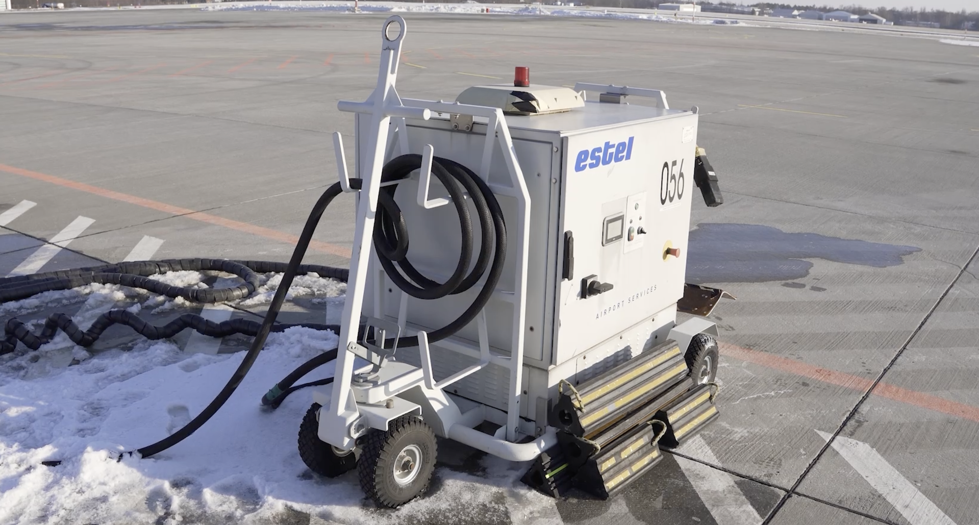 Zdjęcie przedstawia G P U, czyli agregat prądotwórczy zasilany prądem. Jest to prostopadłościenne urządzenie na kołach, do którego podłączony jest długi i kabel o dużej średnicy.