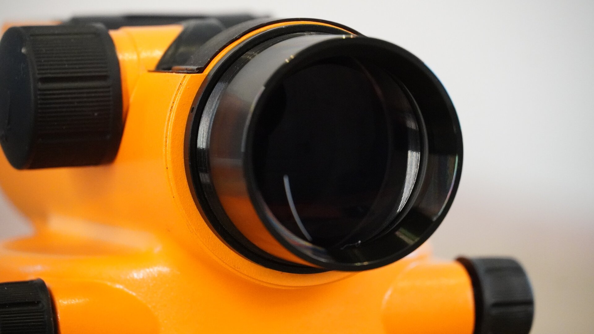 Zdjęcie przedstawia zbliżenie niwelatora od strony obiektywu.
