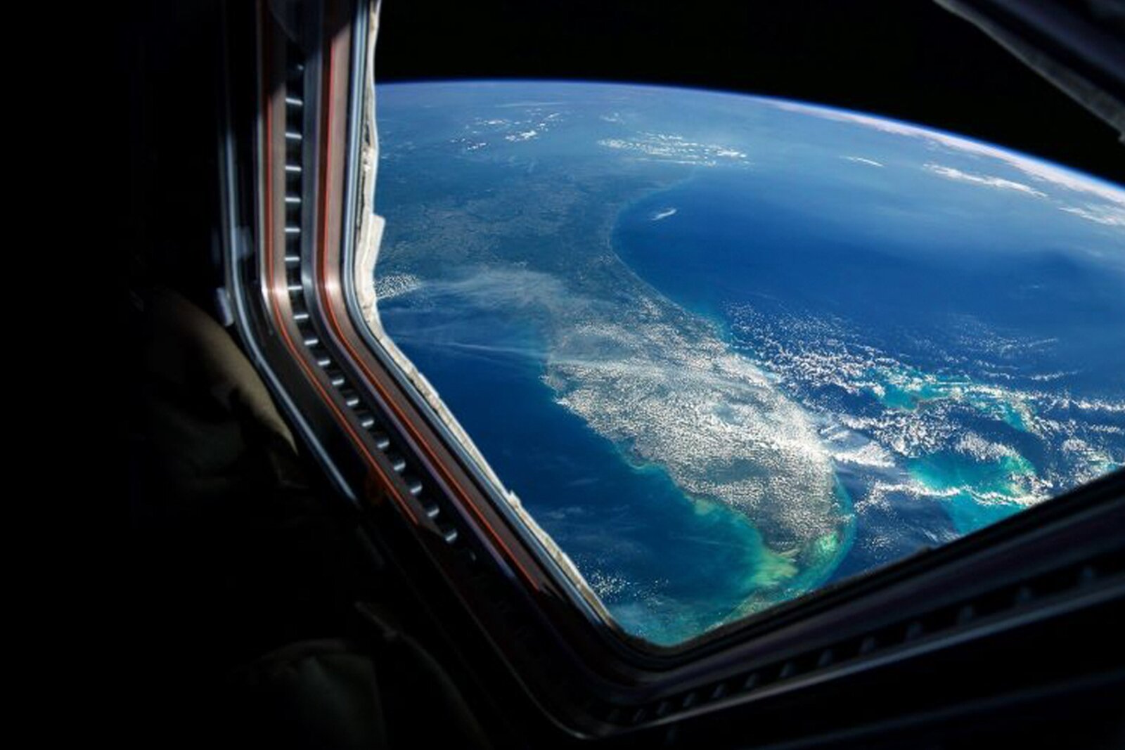 Zdjęcie przedstawia fragment kuli ziemskiej widziany z okna statku kosmicznego.