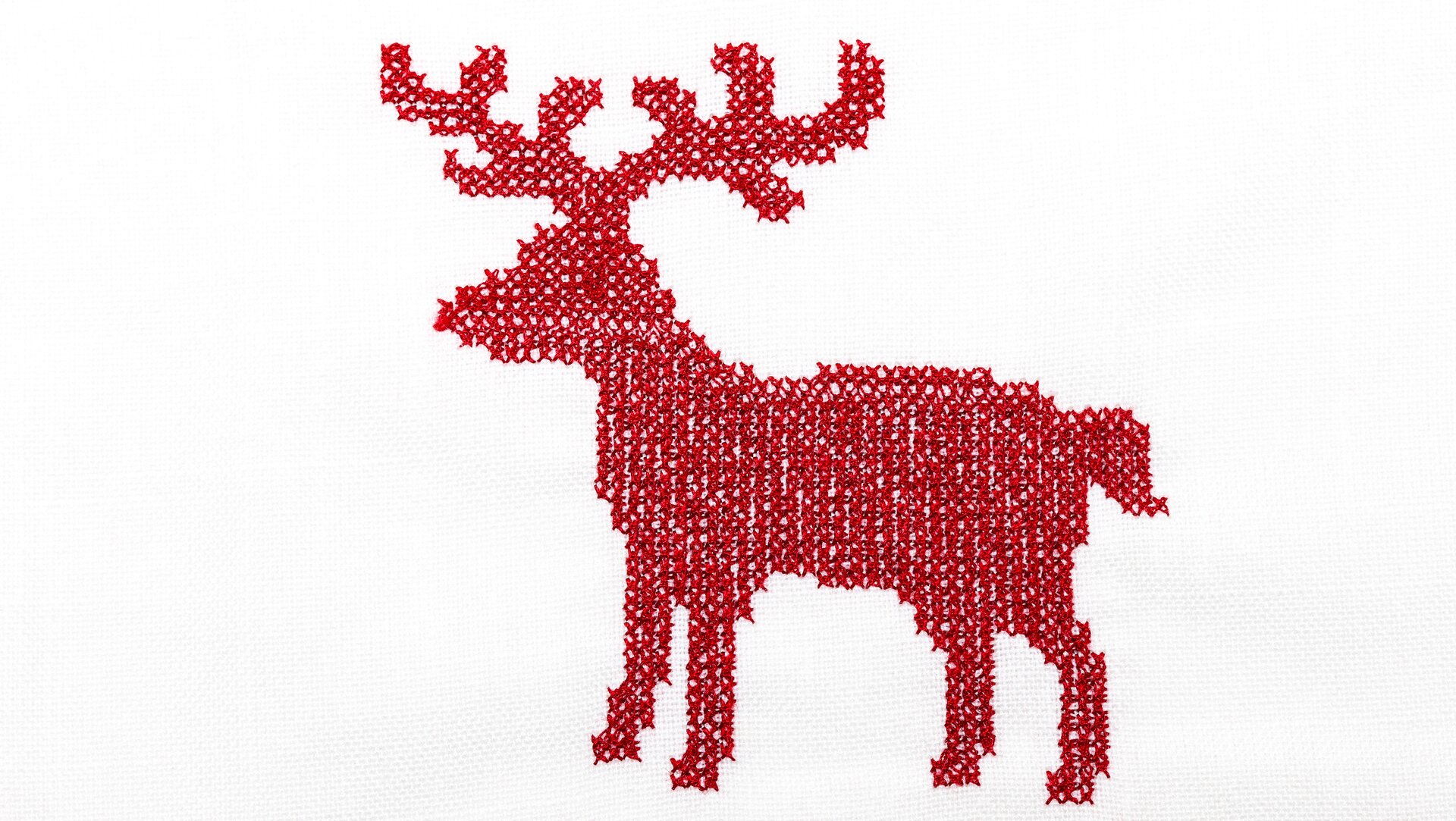 Ilustracja przedstawiająca wyhaftowanego, czerwonego jelenia. Jest to przykład braku symetrii.