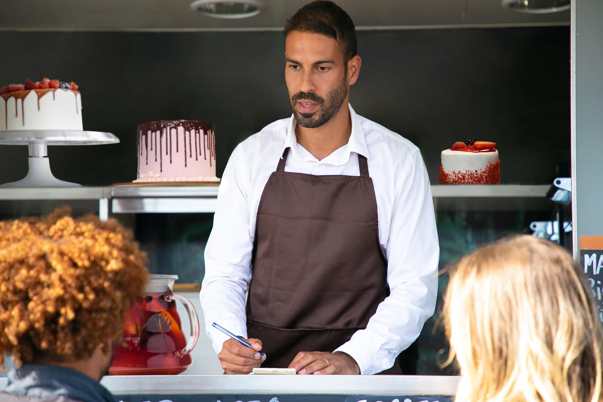 Ilustracja przedstawia sprzedawcę w cukierni. W kolejce stoją dzieci.