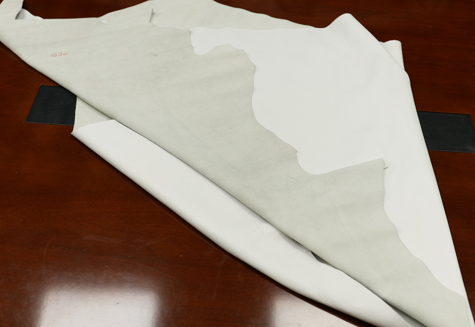 Zdjęcie przedstawia płat skóry garbowanej ekologicznie metodą wet white. Od strony lica i mizdry skóra jest biała. 
