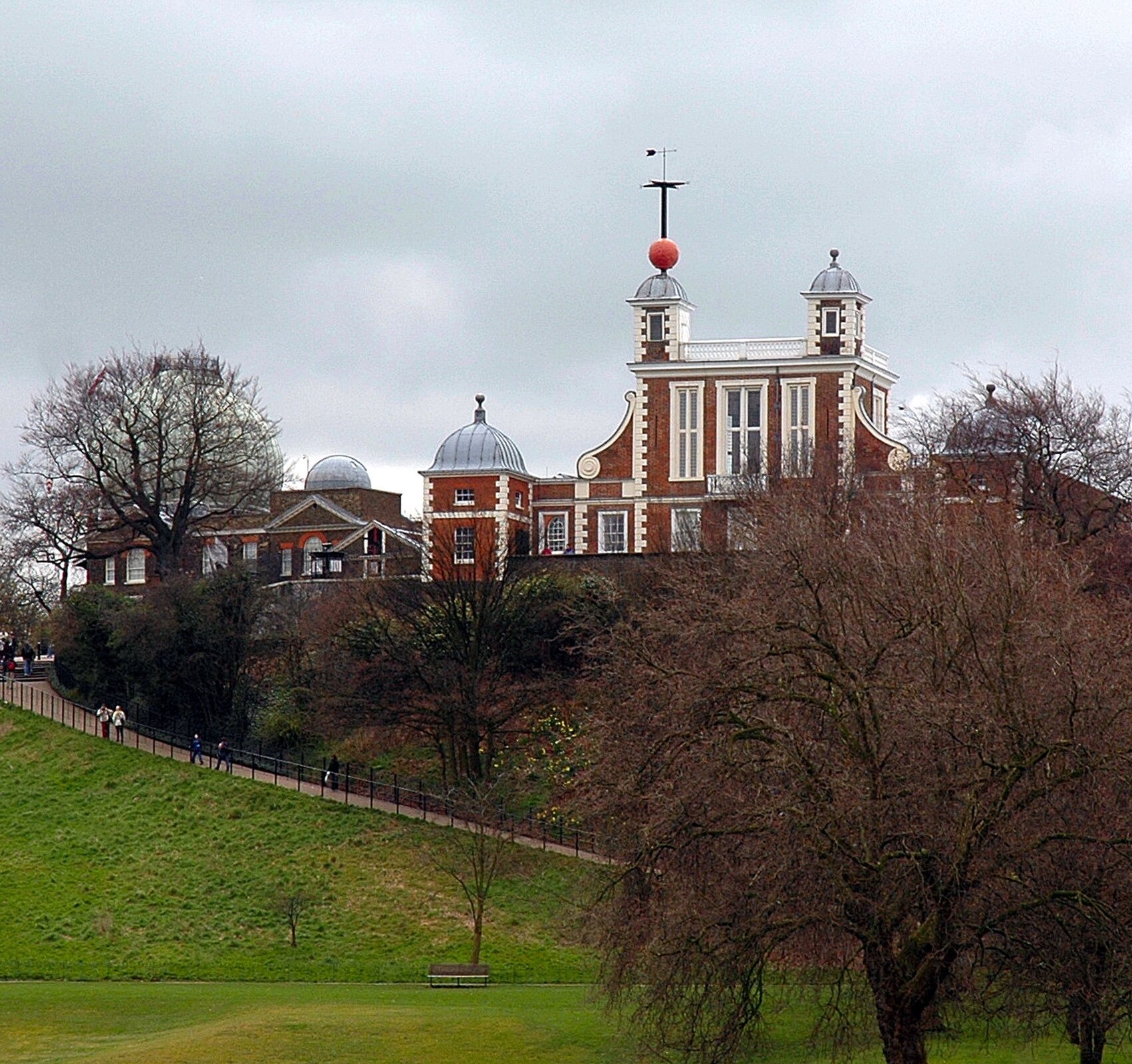 
Ilustracja przedstawia Królewskie obserwatorium w Greenwich w Londynie - widok od strony stóp wzgórza, na którym jest usytuowane obserwatorium.