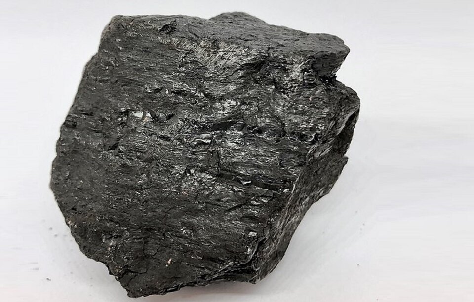 Na zdjęciu przedstawiono węgiel kamienny. Skała o barwie ciemnoszarej, posiada delikatny połysk.