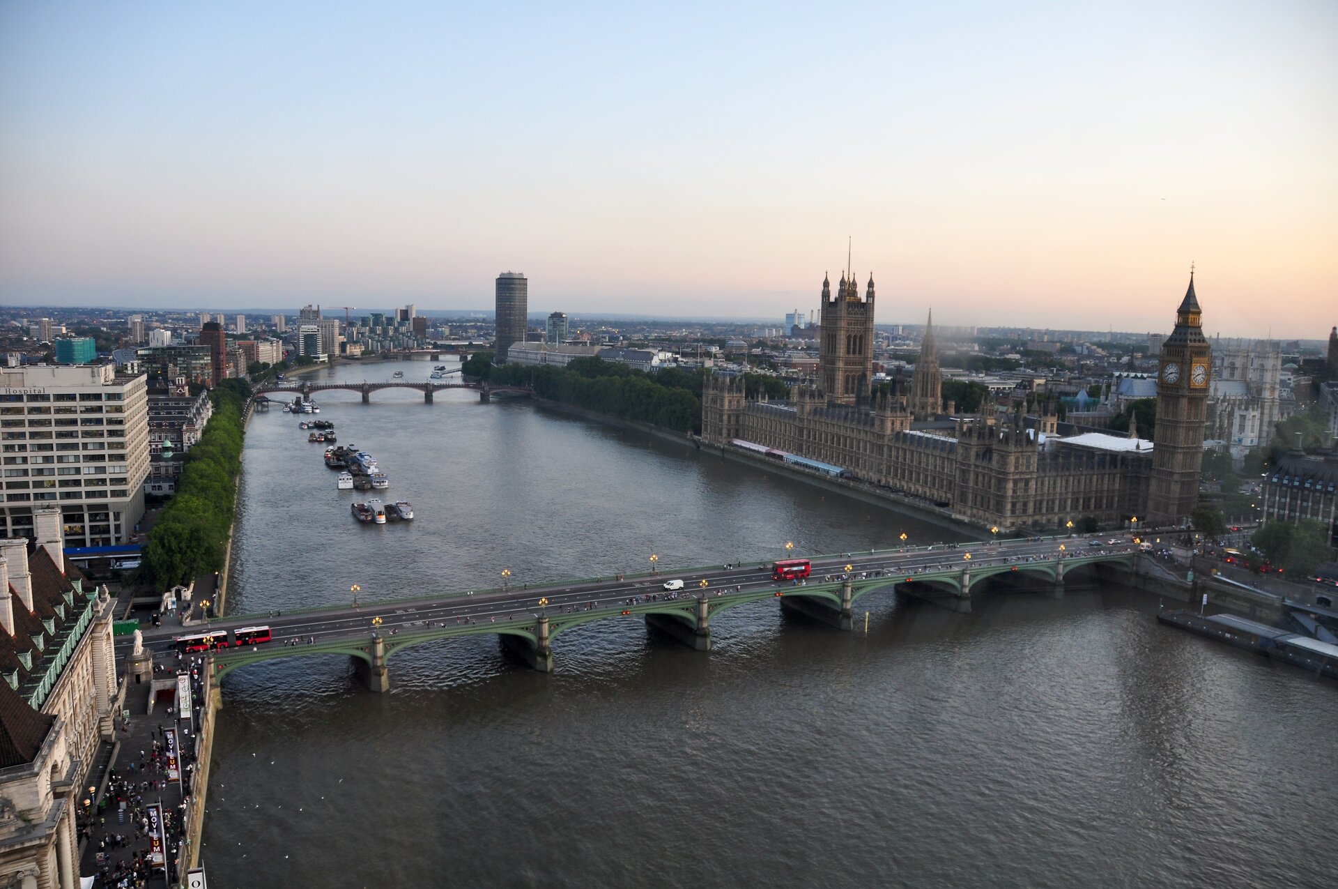 Na zdjęciu szeroka rzeka w obszarze zabudowanym. Zabytkowa i nowoczesna zabudowa Londynu, most.