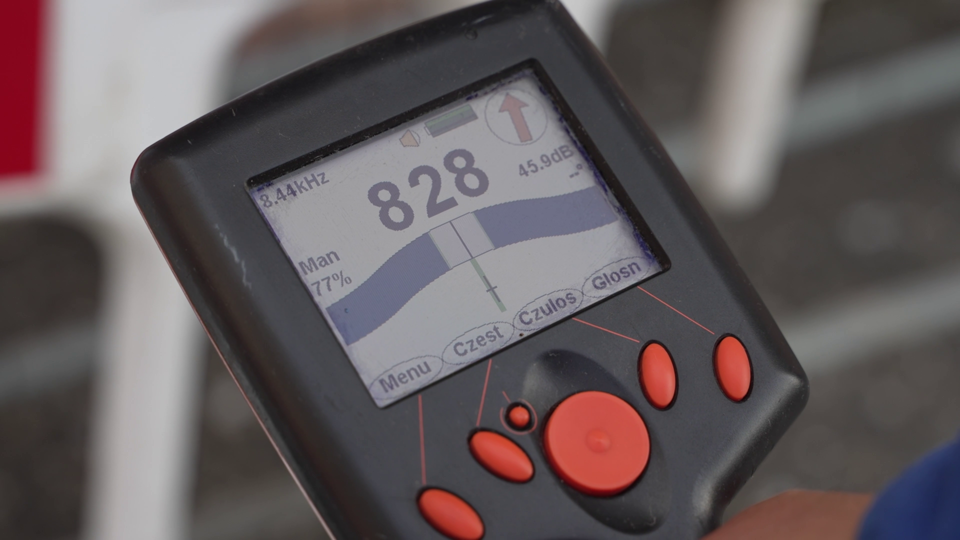 Na ekranie zbliżenie na wyświetlacz sygnalizatora, poniżej którego znajdują się przyciski.