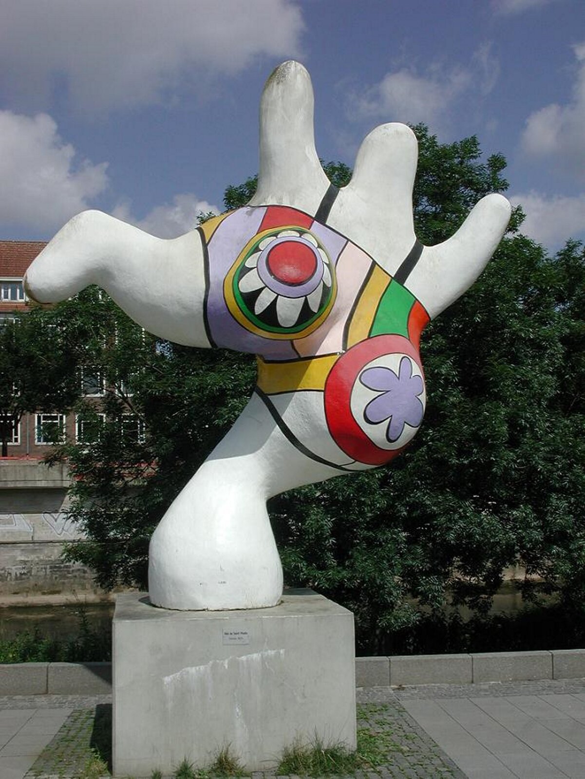 Ilustracja przedstawia pracę Niki de Saint Phalle „Nana”. Dzieło pochodzi z 1974 roku. Obecnie możemy je znaleźć w Hanowerze w Niemczech. Na fotografii widzimy dwie zniekształcone, kolorowe figury. Figury kształtem przypominają sylwetki postaci o dynamicznych ruchach. W tle widoczne są drzewa. Autorką pracy jest francuska rzeźbiarka oraz malarka. W swoich pracach bardzo często wykorzystywała motyw kobiecego ciała.