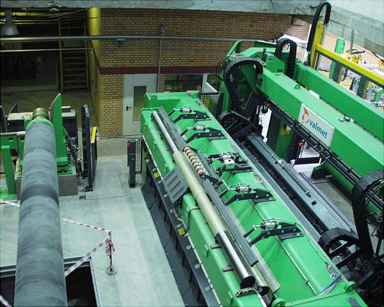 Zdjęcie przedstawia odwijak pełnego tambora. Jest to urządzenie o dużych gabarytach wyposażone w rolki do nawijania papieru.