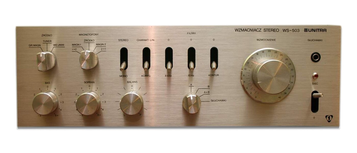 Na zdjęciu widoczny jest prostokątny panel wzmacniacza mocy w kolorze srebrnym. Na panelu w górnej części, od lewej widoczne są dwa okrągłe pokrętła, powyżej których znajdują się nieczytelne napisy. Na prawo od nich widocznej jest pięć suwaków, powyżej których znajdują się nieczytelne napisy. Na panelu w dolnej części, od lewej widoczne są cztery okrągłe pokrętła, powyżej których znajdują się nieczytelne napisy. Na prawo widoczne jest jedno duże, okrągłe pokrętło, powyżej którego znajduje się napis Wzmacniacz stereo WS‑503 i nazwa firmy. Na prawo od pokrętła od góry – czarne kółko – gniazdko, małe czarne kółko i suwak.