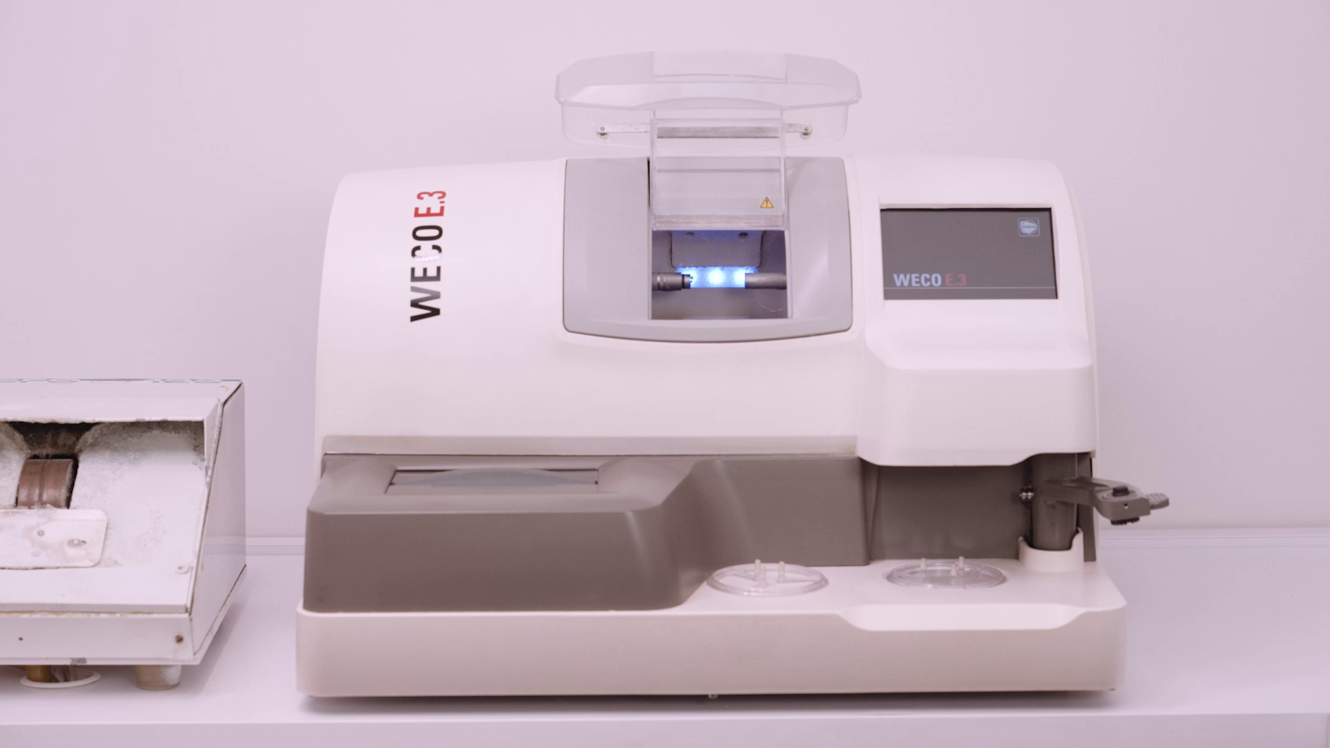 Grafika przedstawia automat szlifierski. Jest to wysokiej klasy sprzęt optyczny, który posiada optymalne rozwiązanie, służące do szlifowania soczewek o dużej krzywiźnie, dostosowanej do okularów. Posiada specjalnie opracowaną tarczę rowkującą, dzięki której możliwe jest wykonanie z najwyższą precyzją nieprzeciętnej jakości rowka.