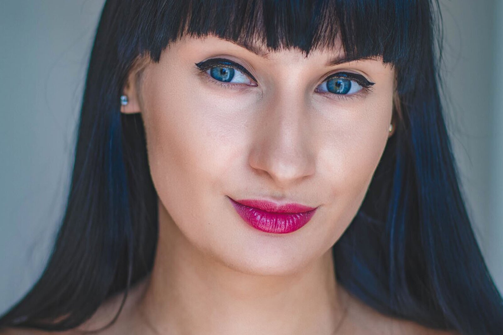 Zdjęcie przedstawia kobietę o czarnych długich i prostych włosach oraz niebieskich oczach.