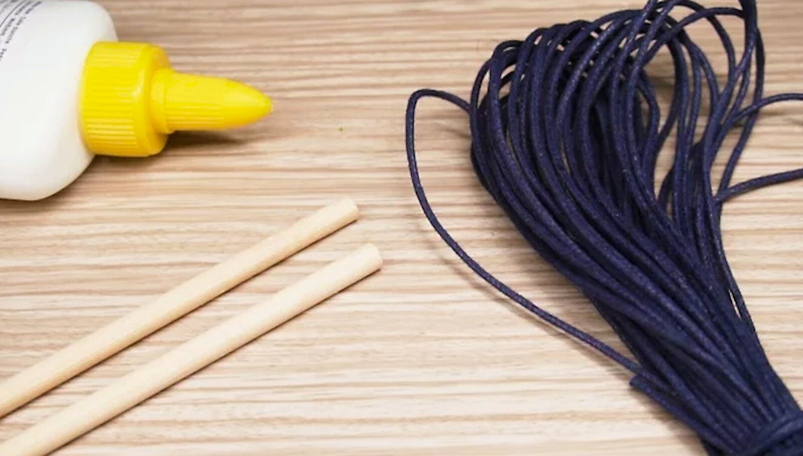 Zdjęcie przedstawia klej, patyczki i sznurki.