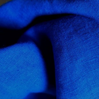 Zdjęcie przedstawia kawałek zwiniętego materiału w kolorze kobaltowym.