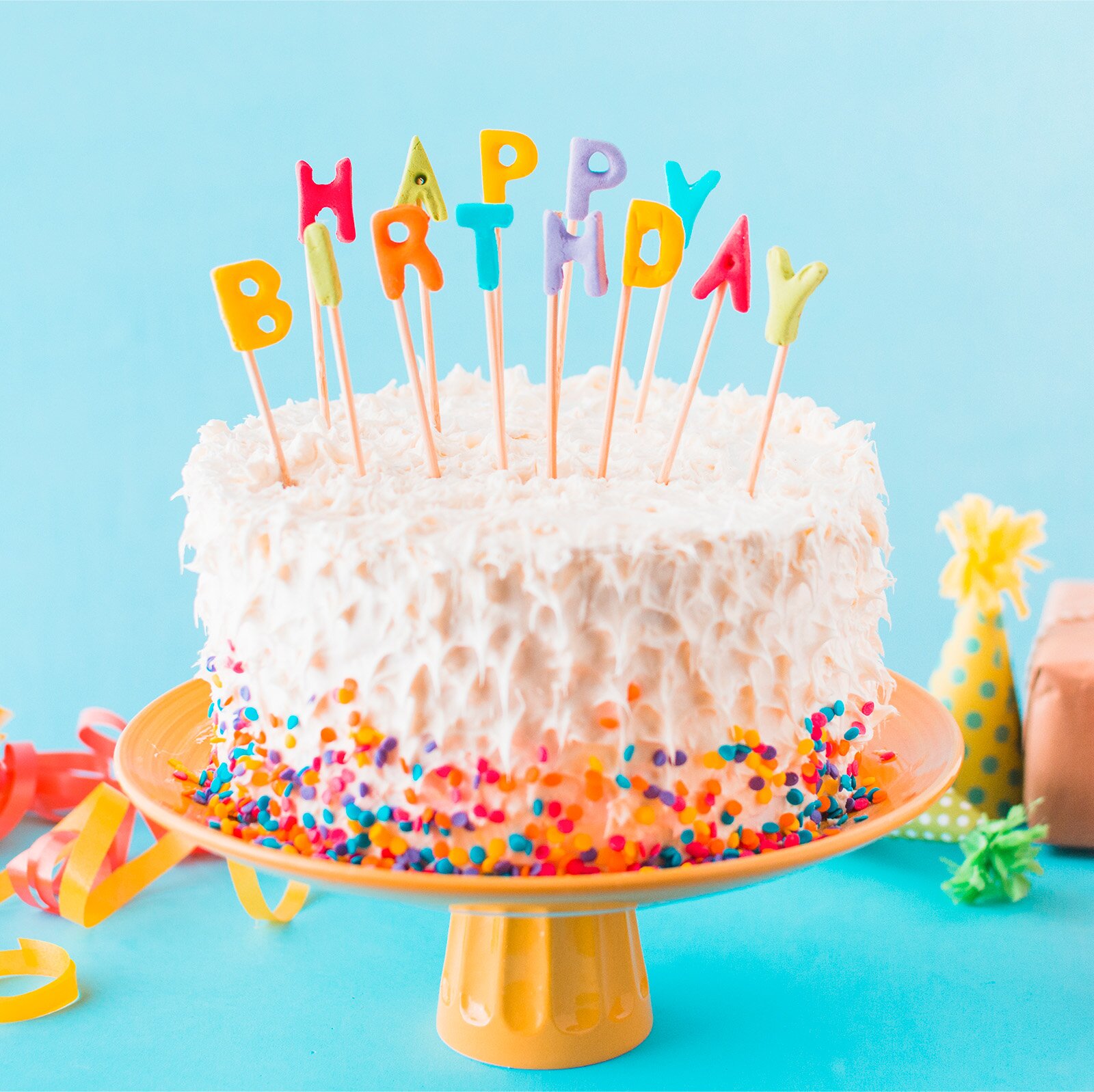 Zdjęcie przedstawia tort urodzinowy. Świeczki zastąpiły literki na patykach, które układają się w napis: HAPPY BIRTHDAY.