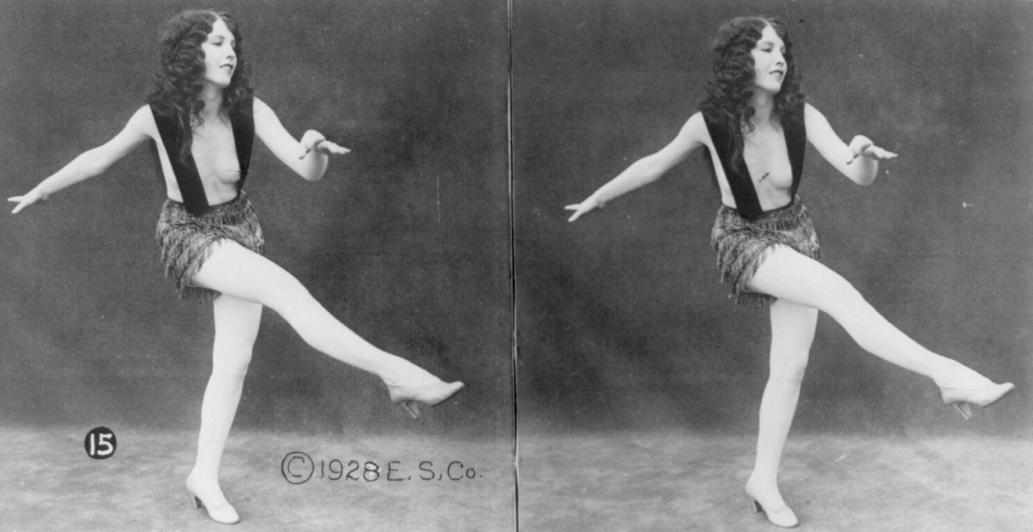 Ilustracja przedstawia dwa razy to samo zdjęcie, na którym widoczna jest tańcząca, młoda kobieta. Ubrana jest w skąpy strój, czyli bardzo krótką spódniczkę i pasy ledwo zakrywające piersi. Ma długie, kręcone włosy. Ma rozstawione ręce i uniesioną w górze prawą nogę.