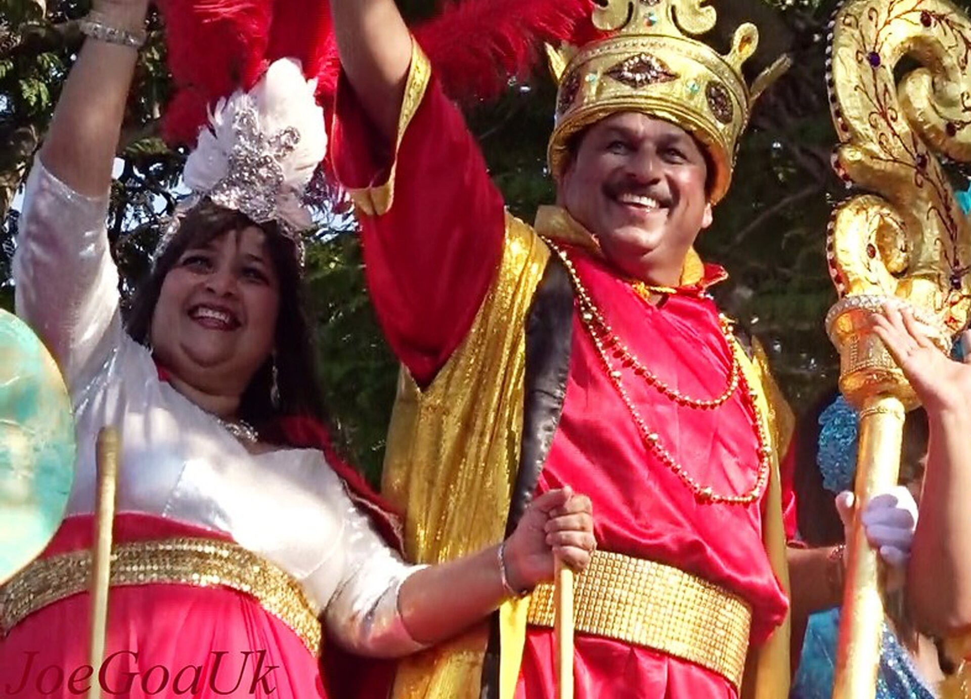 Zdjęcie przedstawia kobietę i mężczyznę w koronie świętujących na paradzie. 