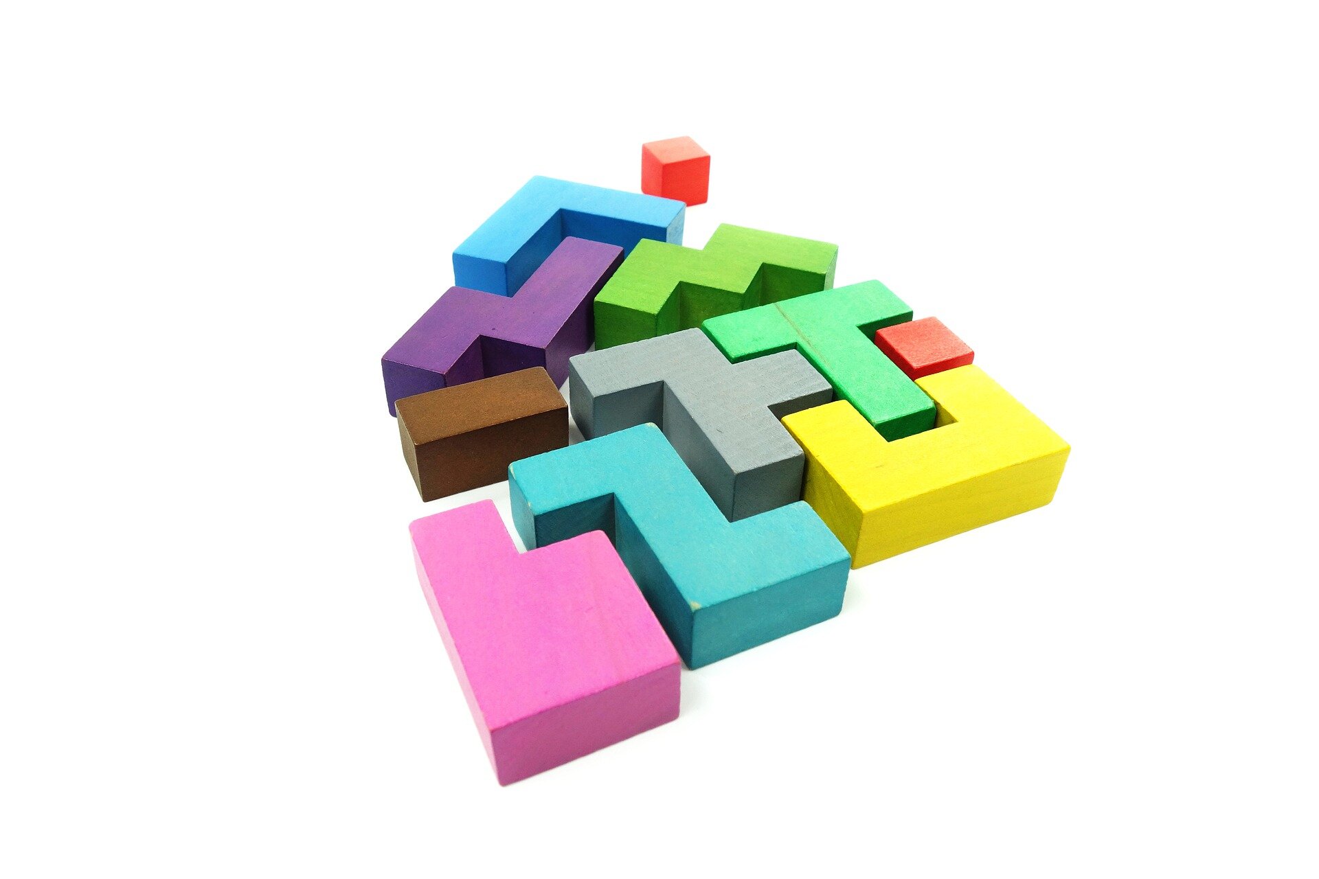 Fotografia przedstawia kolorowe klocki w różnych kształtach i kolorach, które układają się w kształt domu.