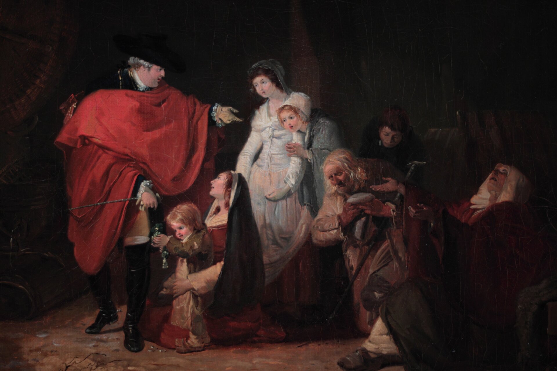 Kliknij, aby powiększyć Na obrazie przedstawiona została grupa postaci. Wśród nich dumna postać mężczyzny w narzuconym na ramiona czerwonym płaszczu, obok niego grupa stojących i klęczących osób w różnym wieku. Mały chłopiec trzyma sakiewkę, którą otrzymał od mężczyzny. Przygląda jej się. Za nim klęczy kobieta, ubrana w suknię i w welonie na głowie. Z kolei za nią stoją dwie kobiety. Jedna z nich wsparta jest na lewym ramieniu drugiej kobiety. Obydwie w czepcach na głowie, jedna z nich w sukni, u drugiej widoczne tylko narzucone na ramiona okrycie. Właśnie do nich mówi coś wspomniany mężczyzna. Z prawej strony kobiet klęczy starzec, za nim pochylony mężczyzna a obok starca, po prawej stronie obrazu, klęczy starsza kobieta z wzniesionymi do góry rękami, w geście błagalnym.