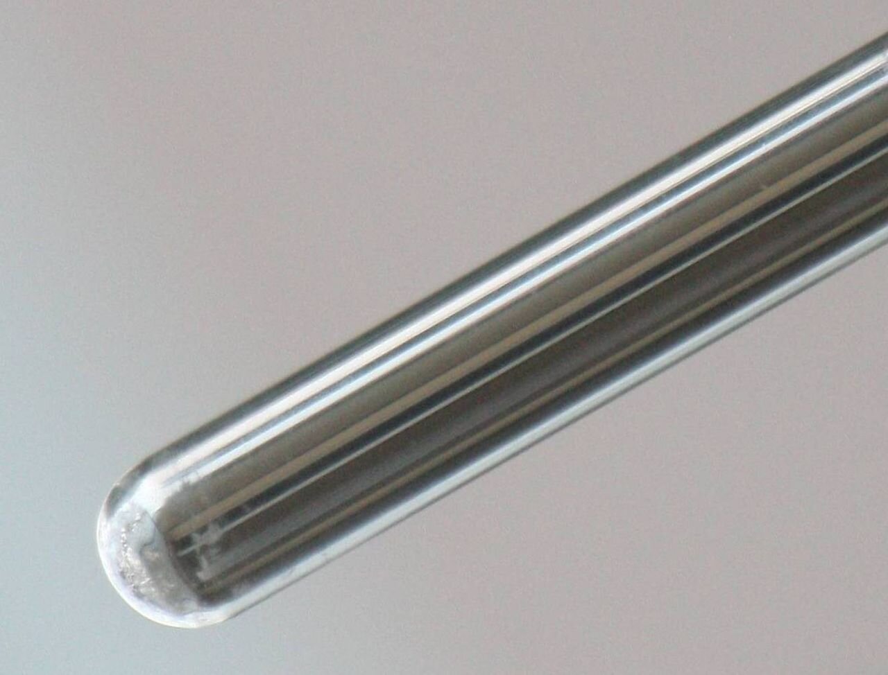 Zdjęcie przedstawia probówkę, na której ściankach jest metaliczne srebro.