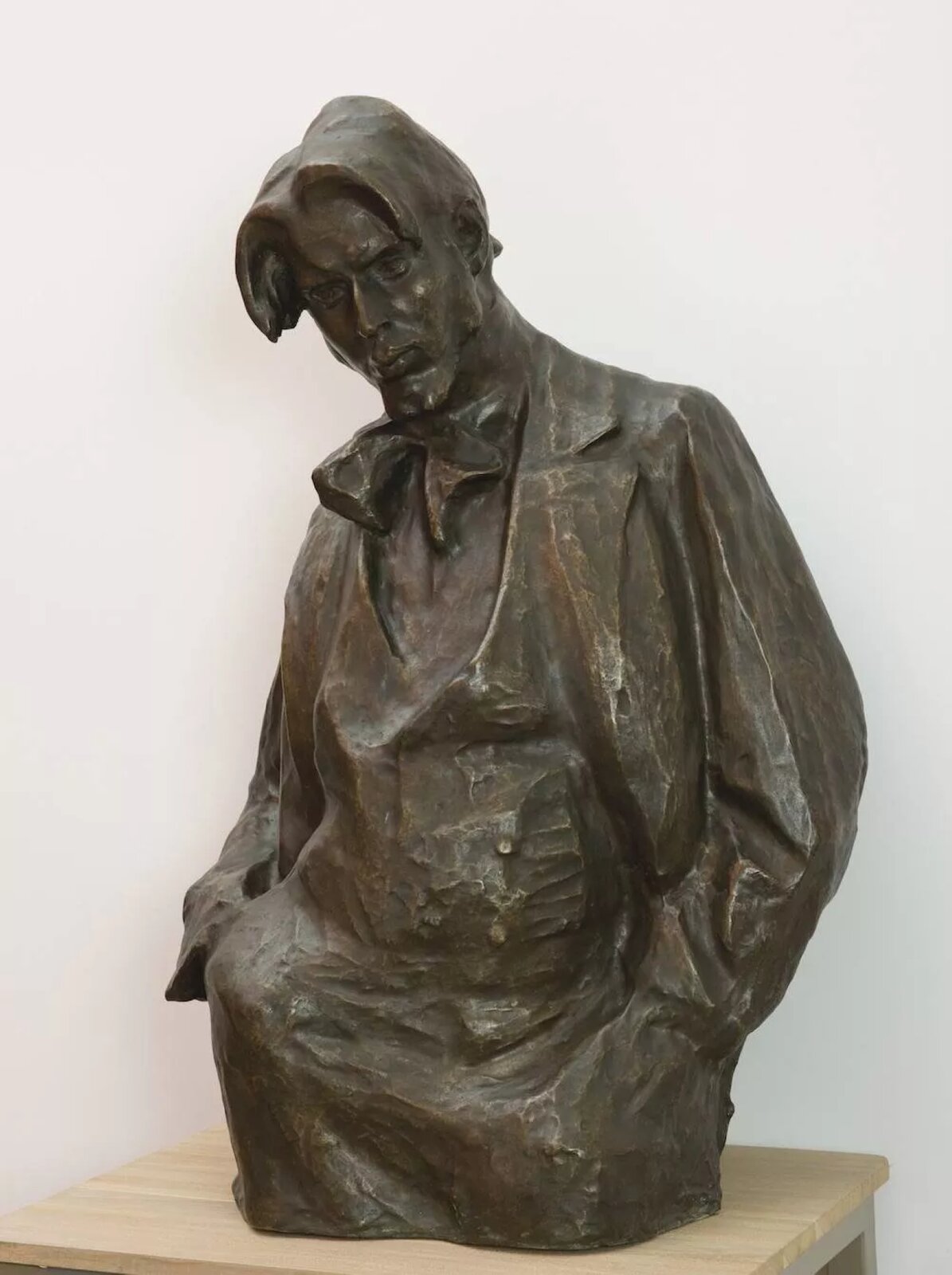 Rzeźba przedstawia portret obejmujący wizerunek Henryka Szczyglińskiego od głowy do ud. Został uwieczniony jako mężczyzna w średnim wieku, o długich włosach i średniej długości koziej bródce. Ubrany jest w długi płaszcz spod którego wystaje apaszka. Szczygliński spogląda się w dół, ręce trzyma w kieszeniach płaszcza.