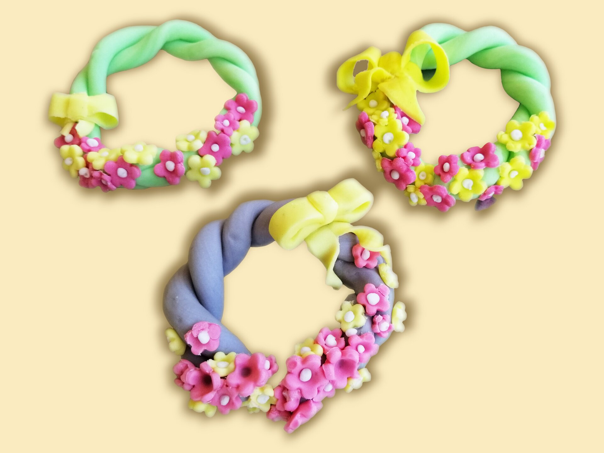 Zaplatane wianki z masy cukrowej, dekorowane drobnymi kwiatkami.