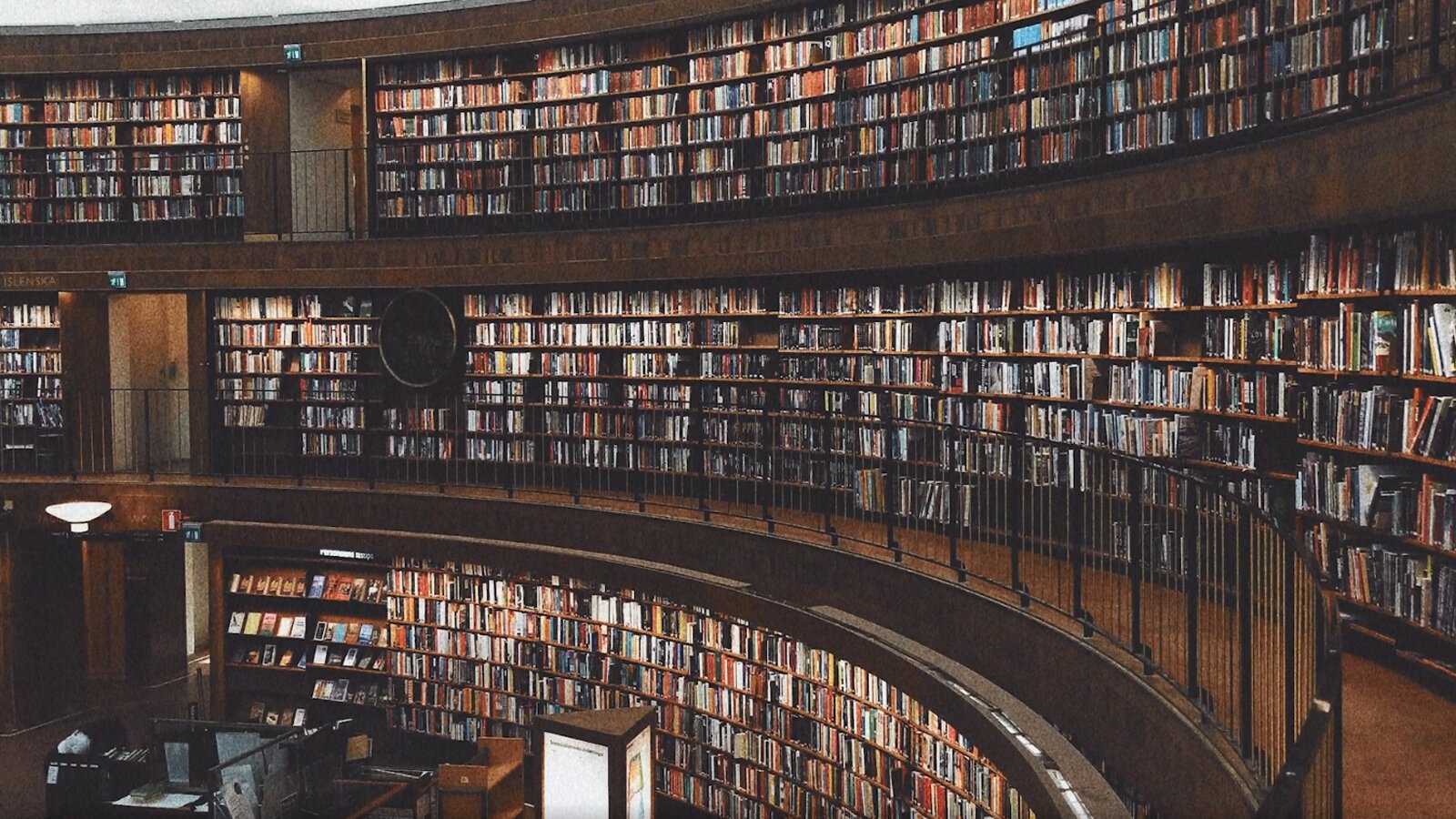   Lesen in der Fremdsprache gibt dir die Chance, deine Sprachkenntnisse zu verbessern sowie Alltagssituationen oder die Kultur besser zu verstehen. Suche dir ein Buch aus, das deinen Interessen entspricht. Am Anfang fällt das Lesen einer Geschichte in deutscher Sprache bestimmt schwer, aber je öfter man zu einem fremdsprachigen Buch greift, desto leichter wird es mit der Zeit. Sind echte Bücher noch zu kompliziert? 
Dann kannst du es auch mit „Lernbüchern" versuchen, bei denen schwierige Vokabeln am Seitenende erklärt werden.
8. Bücher auf Deutsch lesen
Lesen in der Fremdsprache gibt dir die Chance, deine Sprachkenntnisse zu verbessern sowie Alltagssituationen oder die Kultur besser zu verstehen. Suche dir ein Buch aus, das deinen Interessen entspricht. Am Anfang fällt das Lesen einer Geschichte in deutscher Sprache bestimmt schwer, aber je öfter man zu einem fremdsprachigen Buch greift, desto leichter wird es mit der Zeit.
Opis: Ilustracja ukazuje przestronne wnętrze, gdzie na trzech kondygnacjach ściany są wypełnione regałami z ogromnym księgozbiorem.
