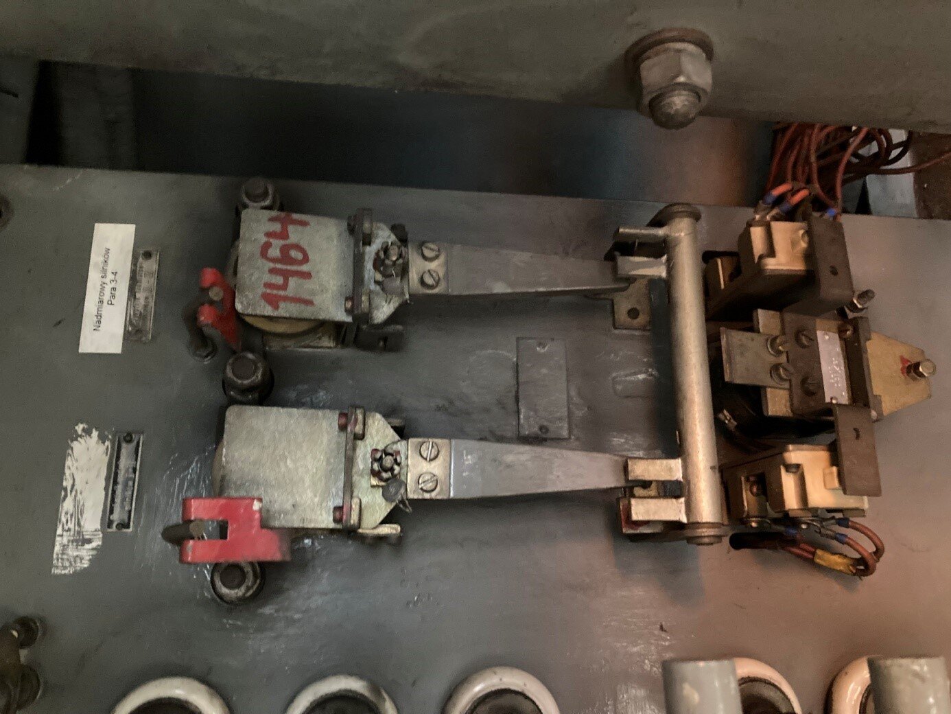 Na zdjęciu widać dwa przekaźniki nadmiarowo prądowe. Podpisane są tabliczkami dla oznaczenia który służy do obsługi której pary silników. Składają się one z prostokątnej płytki z przykręconym trójkątnym nożem oraz z czerwonymi blokadami wychylenia płytek. Z prawej strony znajduje się pręt ustawiony prostopadle do przekaźników z którego wystają styki. Dolny przekaźnik jest zablokowany w pozycji, w której nóż styka się ze stykiem pręta.