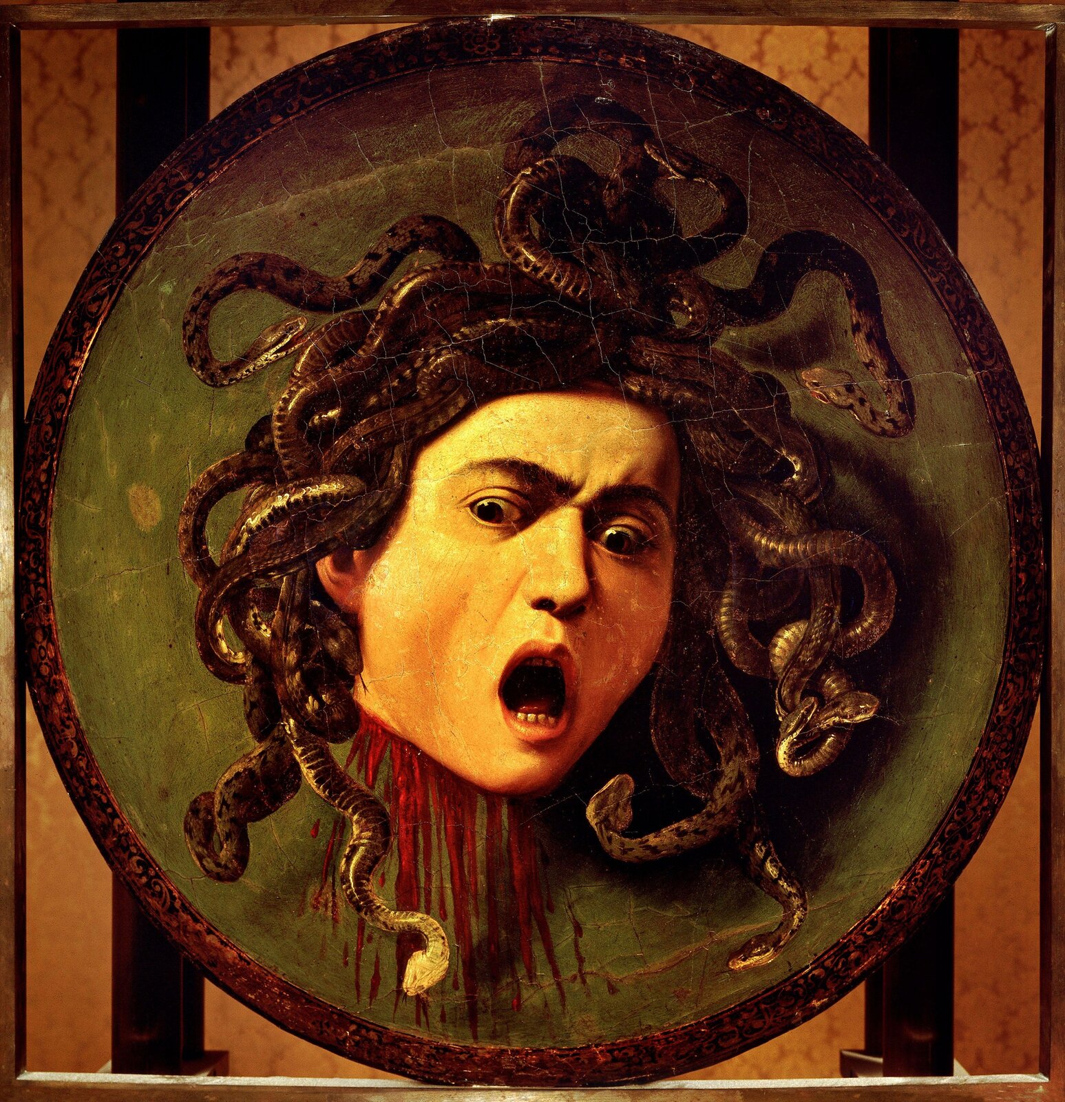 Ilustracja o kształcie kwadratu przedstawia obraz Caravaggia „Głowa Meduzy”. Ukazuje odcięta głowę, z której szyi wytryskuje krew. Na głowie zamiast włosów ma wijące się węże. Przerażenie na twarzy podkreślają szeroko otwarte oczy oraz usta. Głowa Meduzy została umieszczona na okrągłym, zielonym tle, a to z kolei na kwadratowej płaszczyźnie w ciemnym pomarańczowym z dwiema pionowymi, czarnymi pasami.