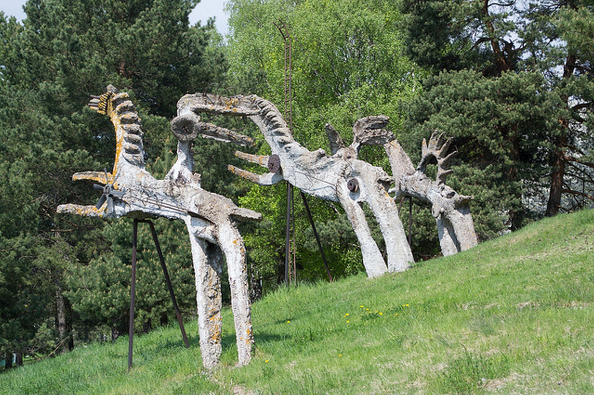 Ilustracja przedstawiająca pomnik autorstwa Władysława Hasiora pt. „Słoneczny rydwan”. Pomnik składa się z zespołu rzeźb przedstawiających konie.