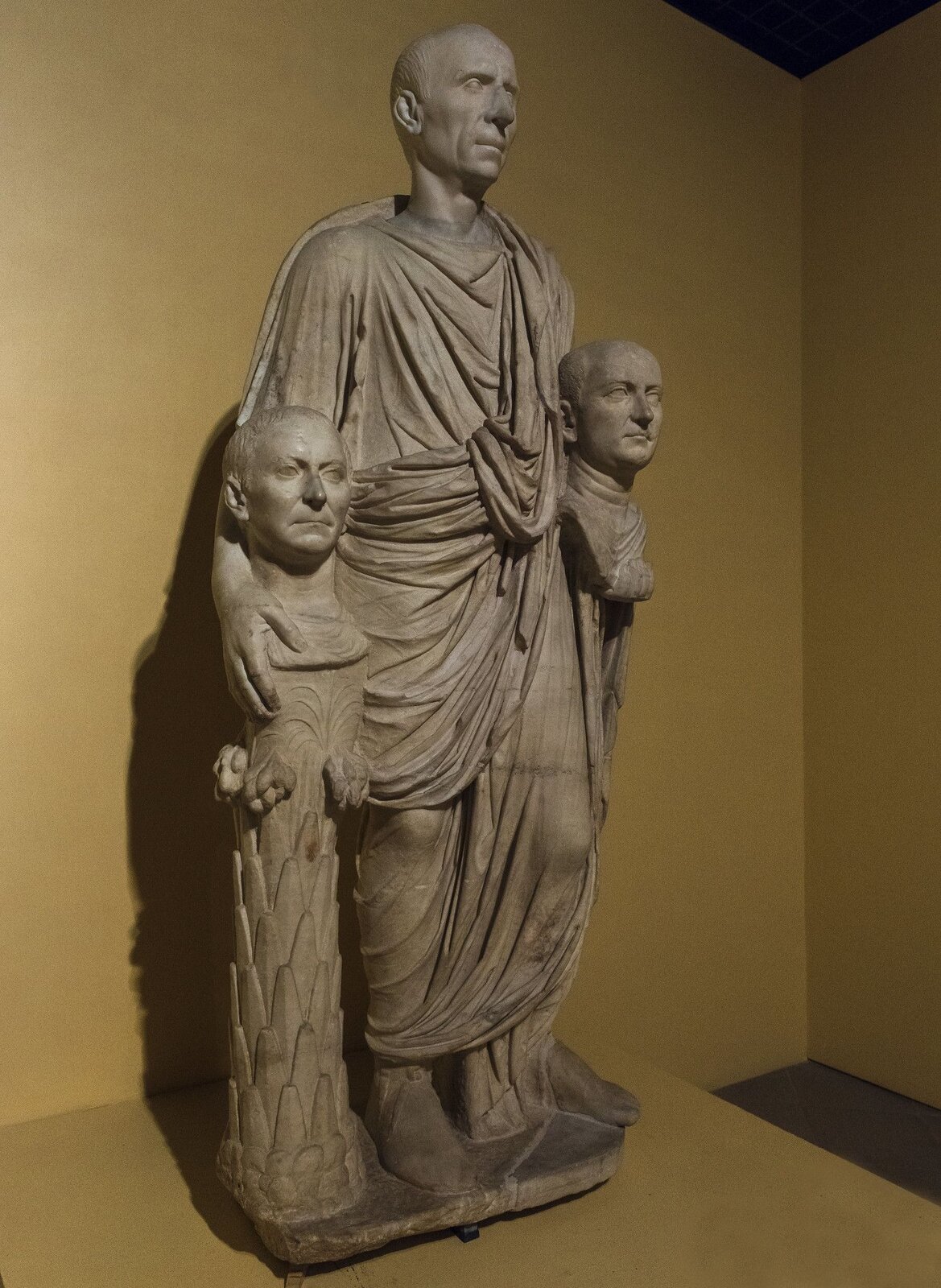 Fotografia nieznanego autora przedstawia rzeźbę Togatusa Barberiniego, rzymskiego senatora, który pozuje na stojąco. Togatus został przedstawiony jako mężczyzna w podeszłym wieku, jest on łysy oraz nie posiada zarostu, ubrany jest w długą szatę sięgającą prawie do kostek. U jego boku widoczne są dwie podobizny jego przodków. Każda z postaci ma poważną minę i nie zdradza emocji. 