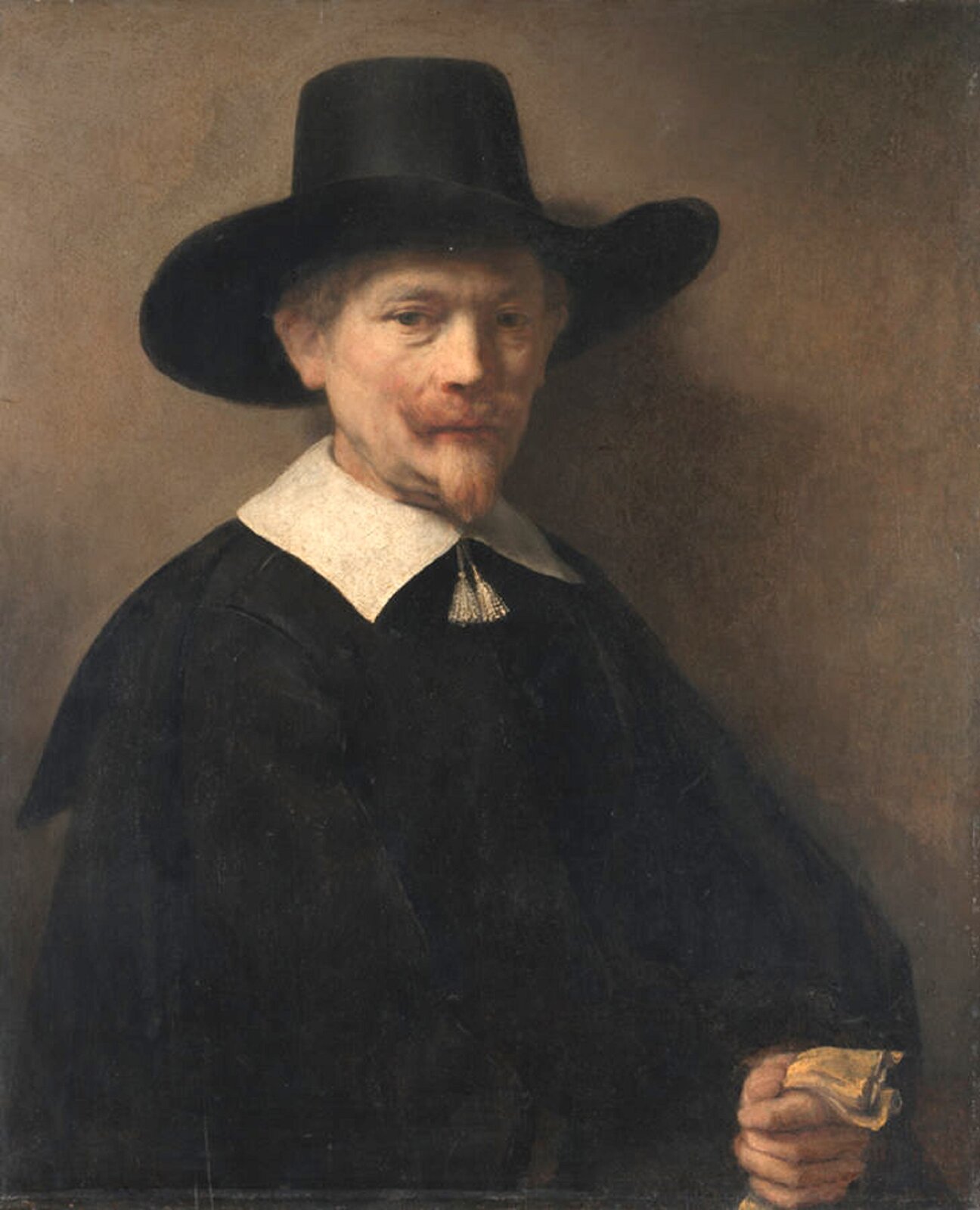 Ilustracja przedstawia obraz olejny „Portret mężczyzny z rękawiczkami”, autorstwa Rembrandta van Rijn. Realistyczny portret ukazuje starszego mężczyznę w czarnym kapeluszu z dużym rondem oraz ciemnym płaszczu z narzuconą na ramiona peleryną i białym kołnierzem. Pomiędzy dwoma częściami kołnierza zwisają dwa frędzelki. Mężczyzna ma jasne wąsy i bródkę. Na jego twarzy rysują się powaga i zamyślenie. Wzrok skierowany jest lekko w dół. Ważnym elementem malowidła jest światło, które miękko wydobywa twarz postaci z półmroku. Kołnierz i jasna twarz postaci stanowią silną dominantę obrazu. Postać trzyma w lewej ręce blado‑żółtą rękawiczkę. Statyczna kompozycja, jednolita beżowa tonacja oraz miękkie światło – te wszystkie elementy podkreślają powagę przedstawionej na obrazie postaci.
