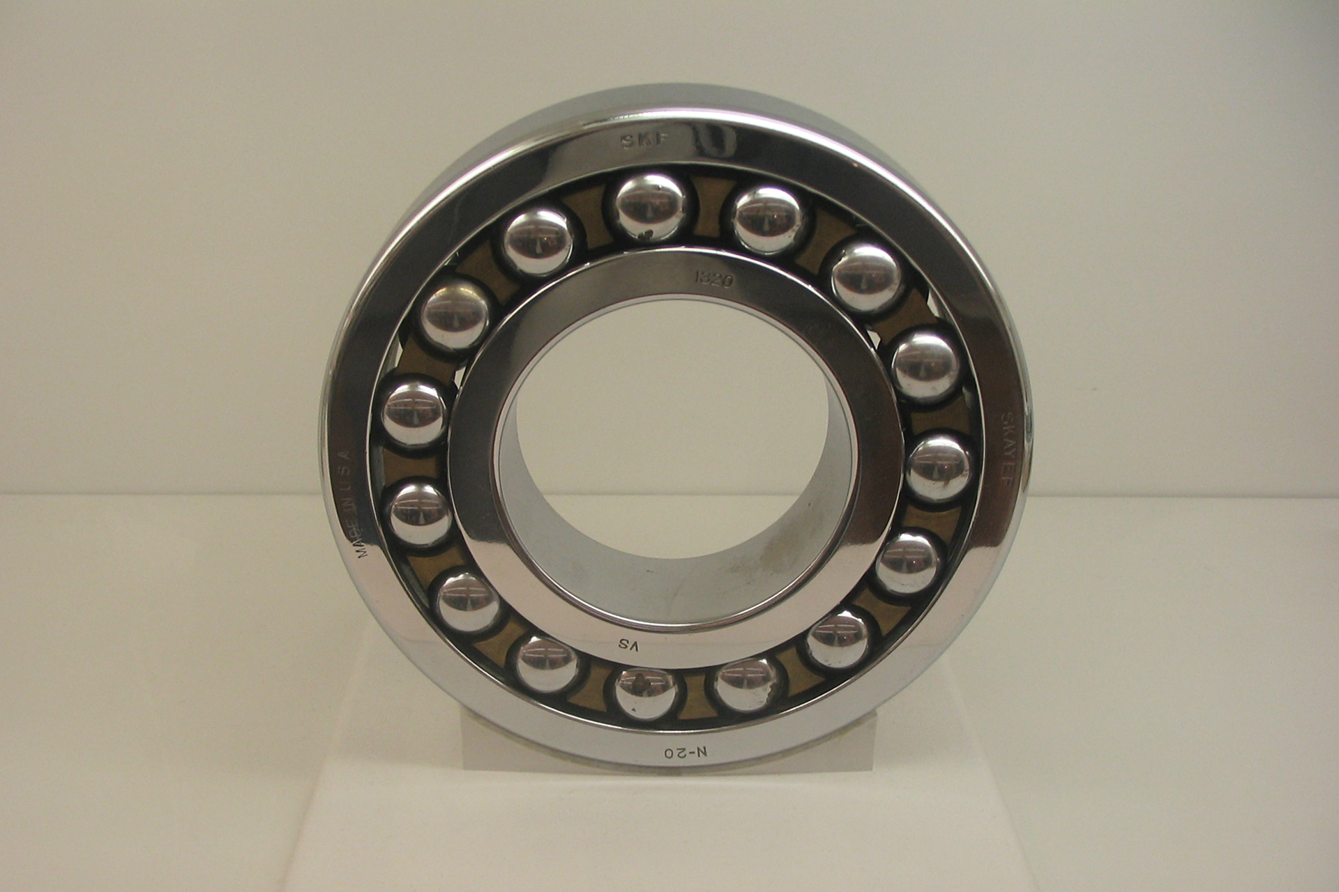 Zdjęcie przedstawia łożysko kulkowe. Składa się ono z zewnętrznego metalowego pierścienia i wewnętrznego mniejszego metalowego pierścienia. Pomiędzy te pierścienie włożonych jest kilkanaście metalowych kulek.