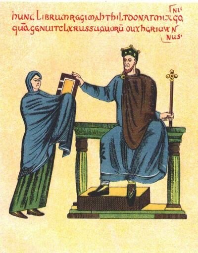 Ilustracja przedstawia władcę siedzącego na tronie. Jest on ubrany w niebieskie szaty i brązowy płaszcz. Na głowie ma koronę, w lewej ręce trzyma berło, a prawą sięga po książkę, którą trzyma kobieta stojąca przed nim. Jest ona ubrana w niebieskie szaty. 