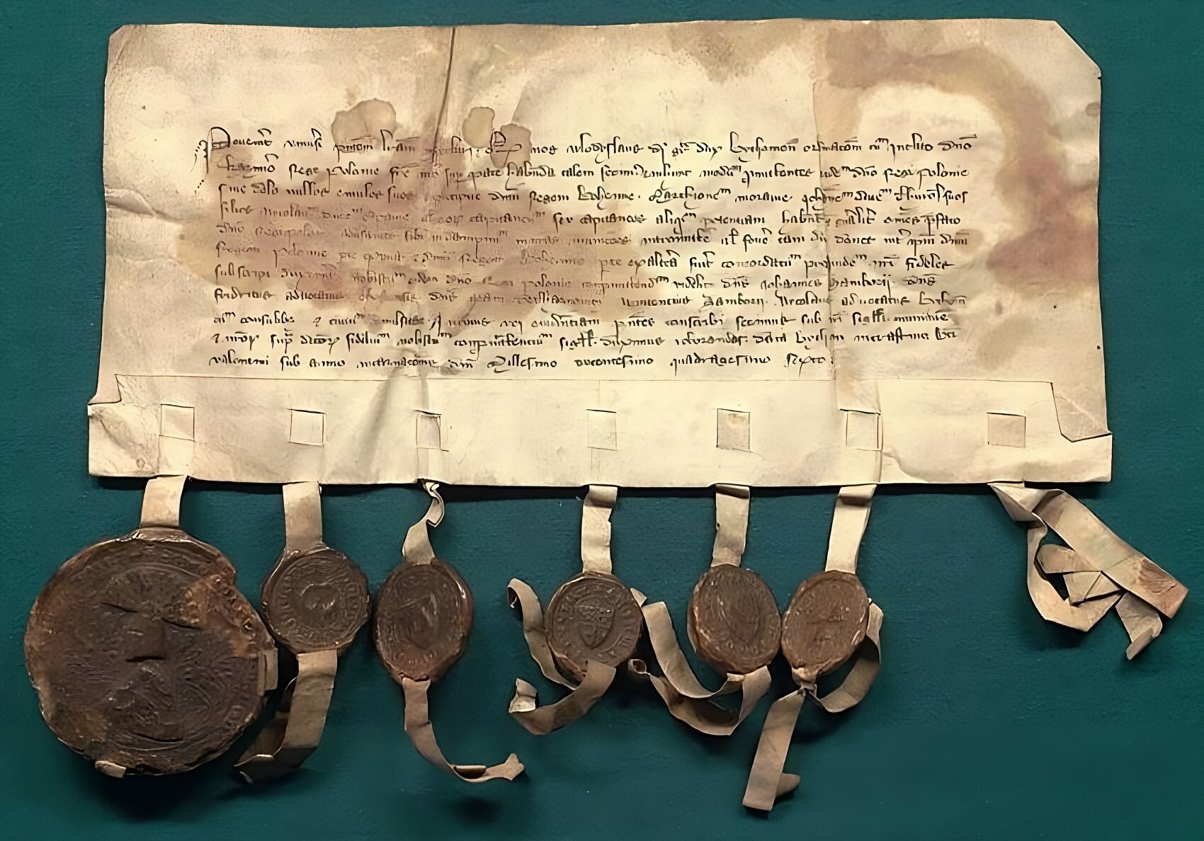 Zdjęcie przedstawia oryginalny dokument sporządzony na pergaminie a jego treść została wypisana pismem odręcznym. U spodu karty zostały przyczepione pieczęcie lakowe.